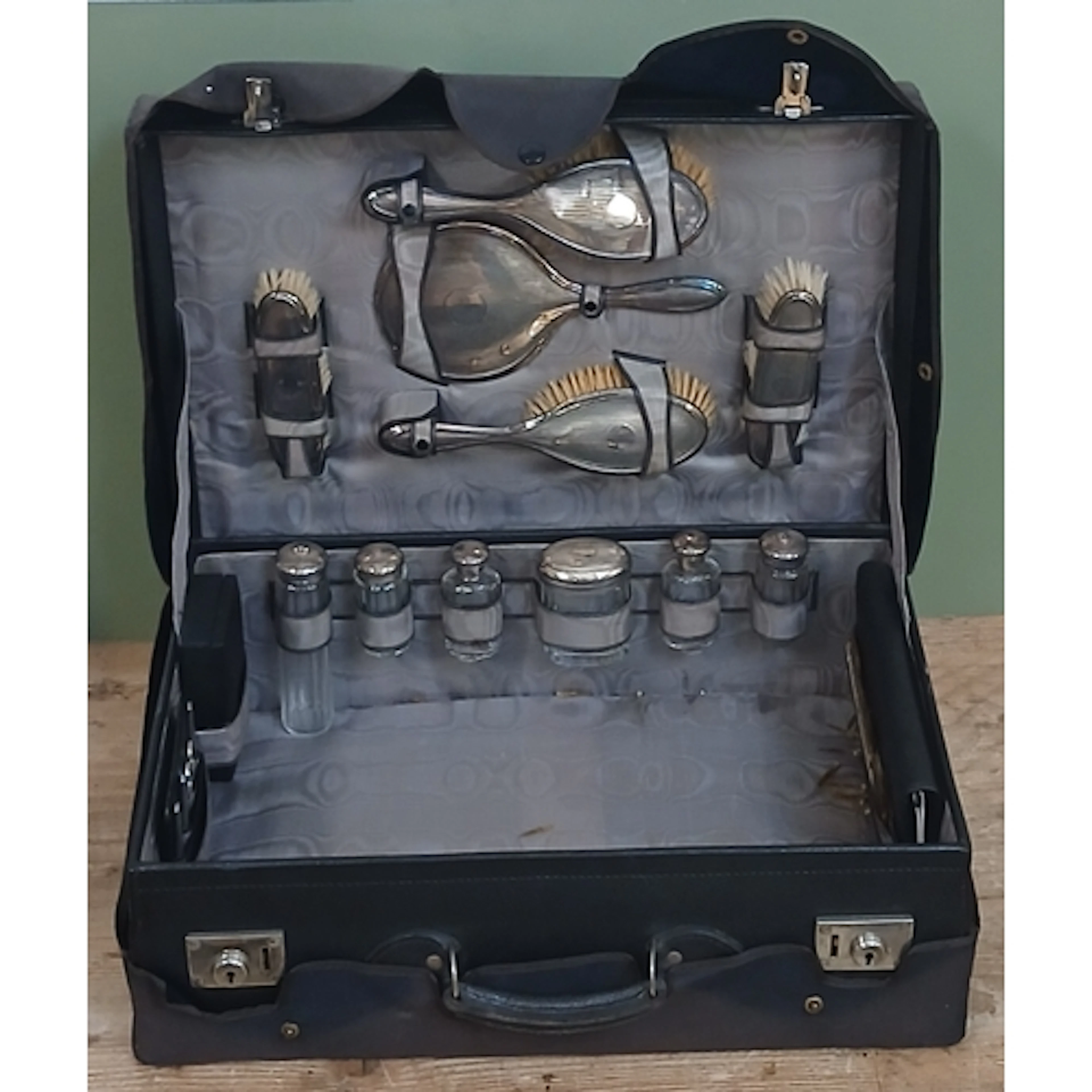 An early 20th century leather case, the interior fitted with...