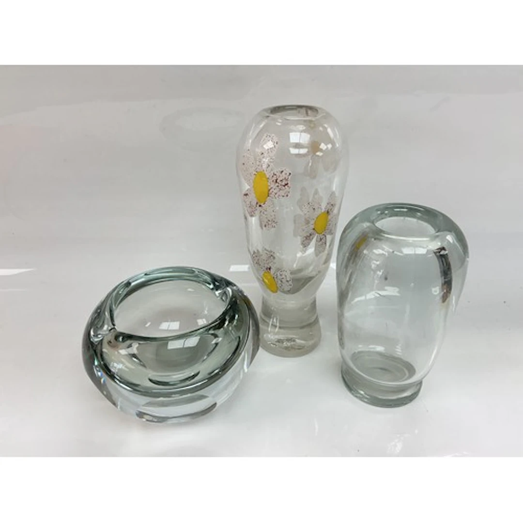 Three clear glass vases, one decorated with daisies, tallest...