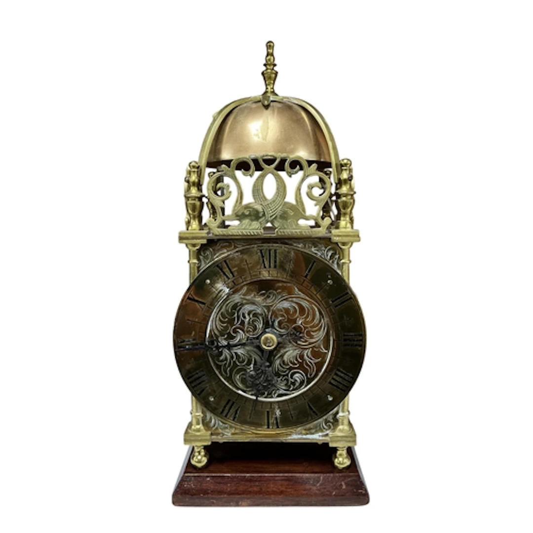 A reproduction brass lantern clock with engraved dial, raise...
