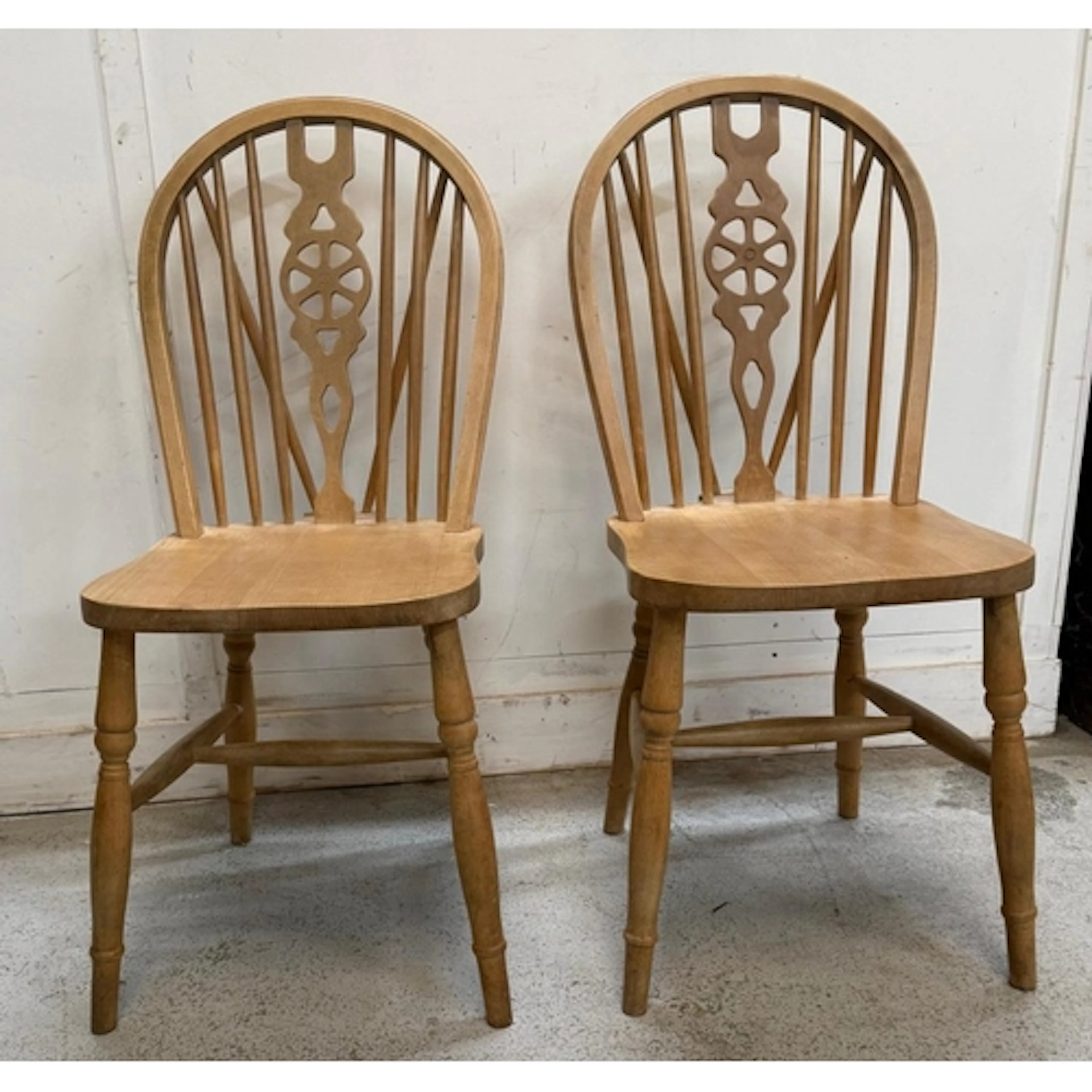 A pair of pine wheel back chairs
