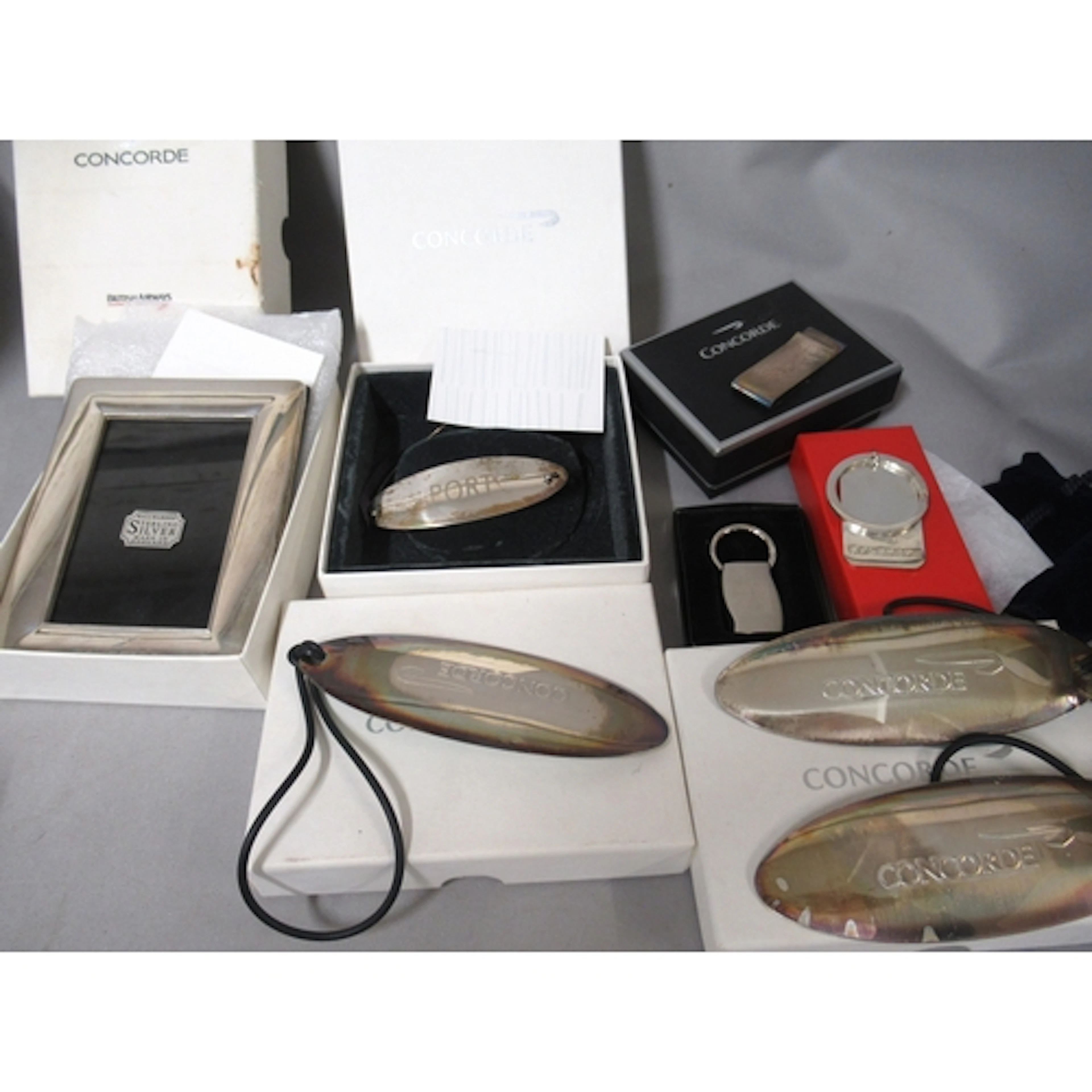 Three Concorde souvenir silver luggage labels, a silver mone...