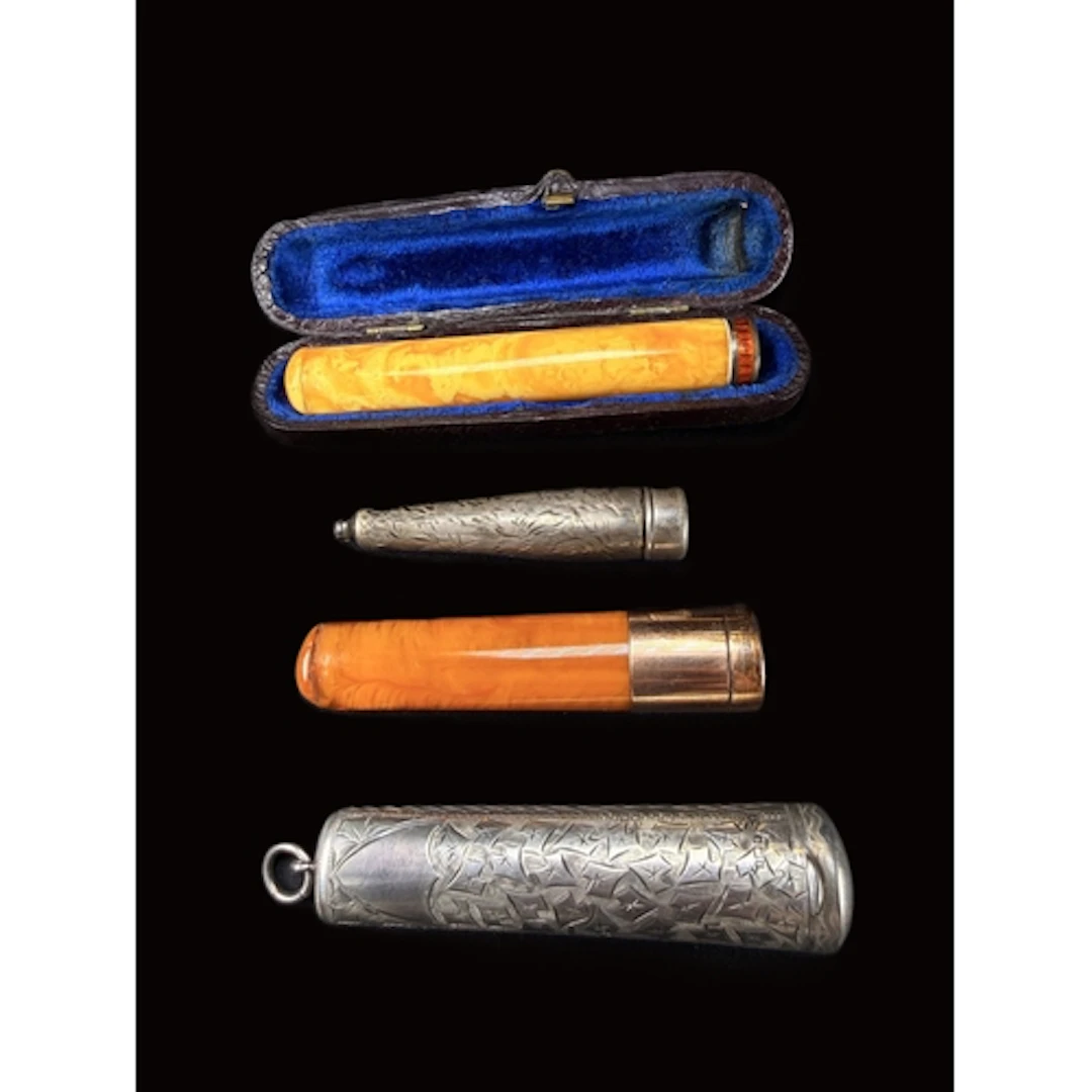 A 9ct gold and abmber Cheroot with a silver case, another sm...