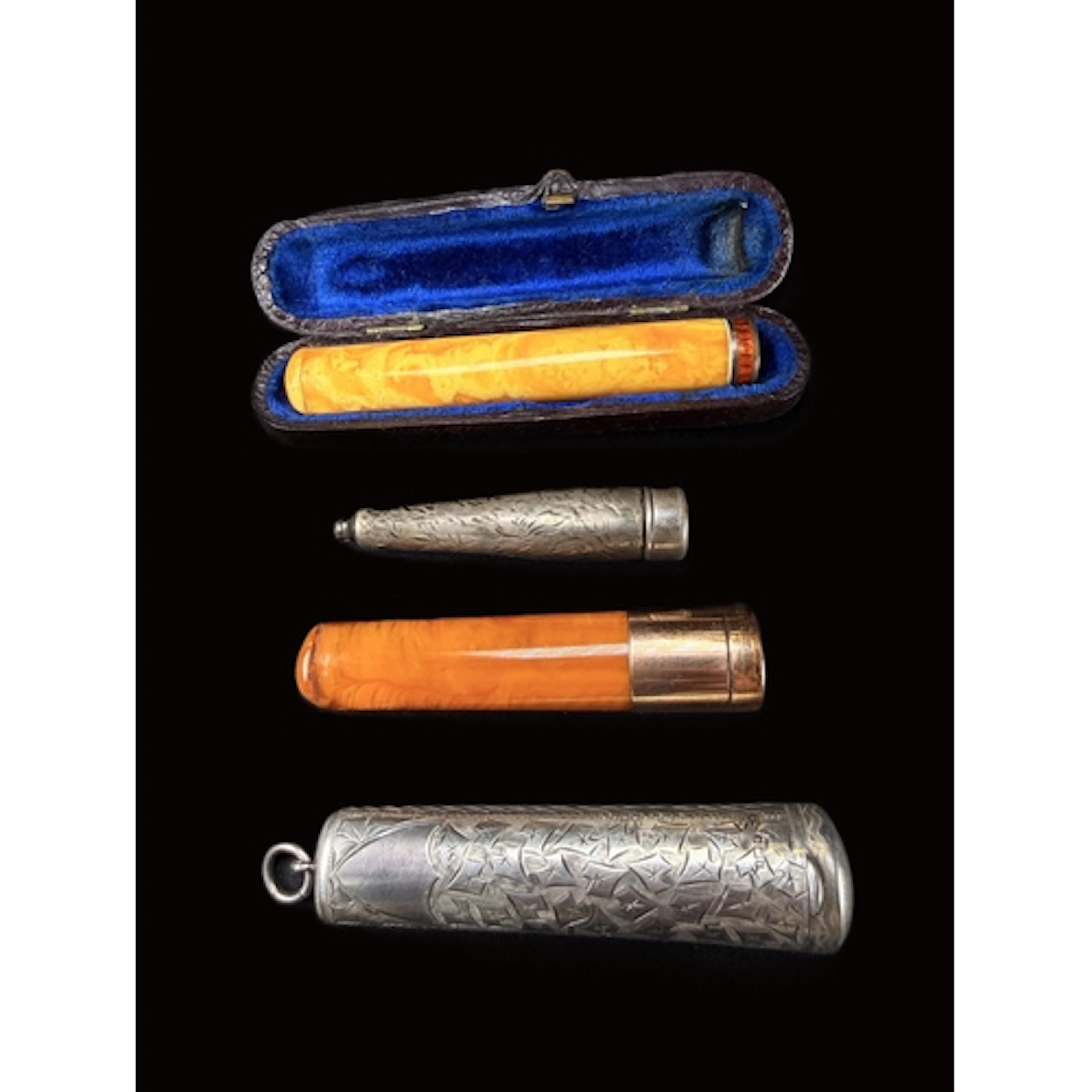 A 9ct gold and abmber Cheroot with a silver case, another sm...