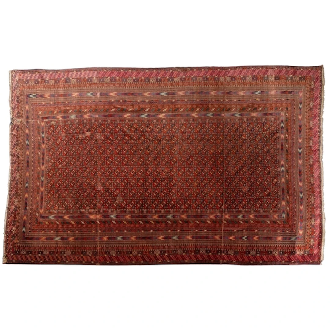 A Turkoman carpet, the wine and indigo panelled field with h...