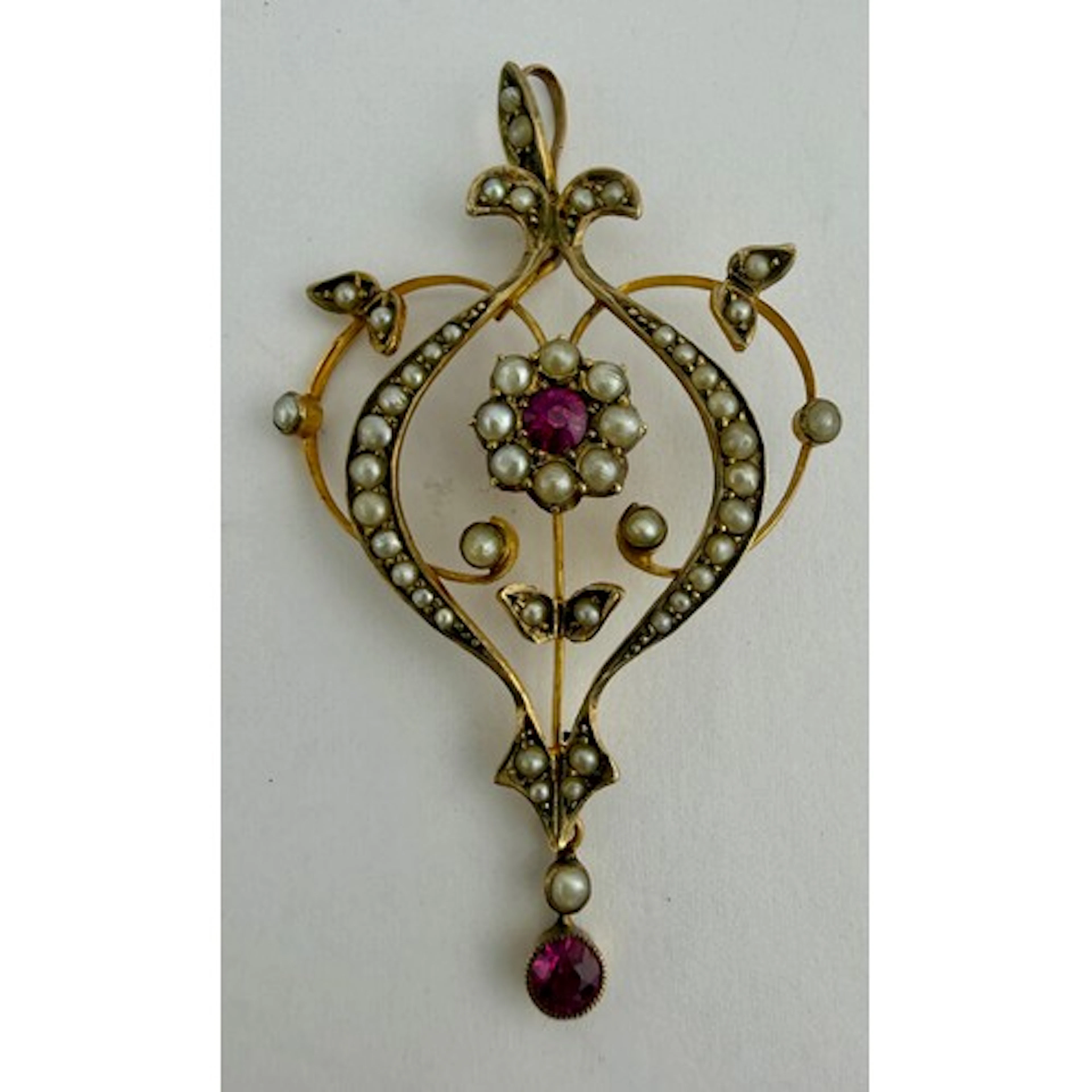 An Edwardian 9 carat gold pendant set with seed pearls and r...