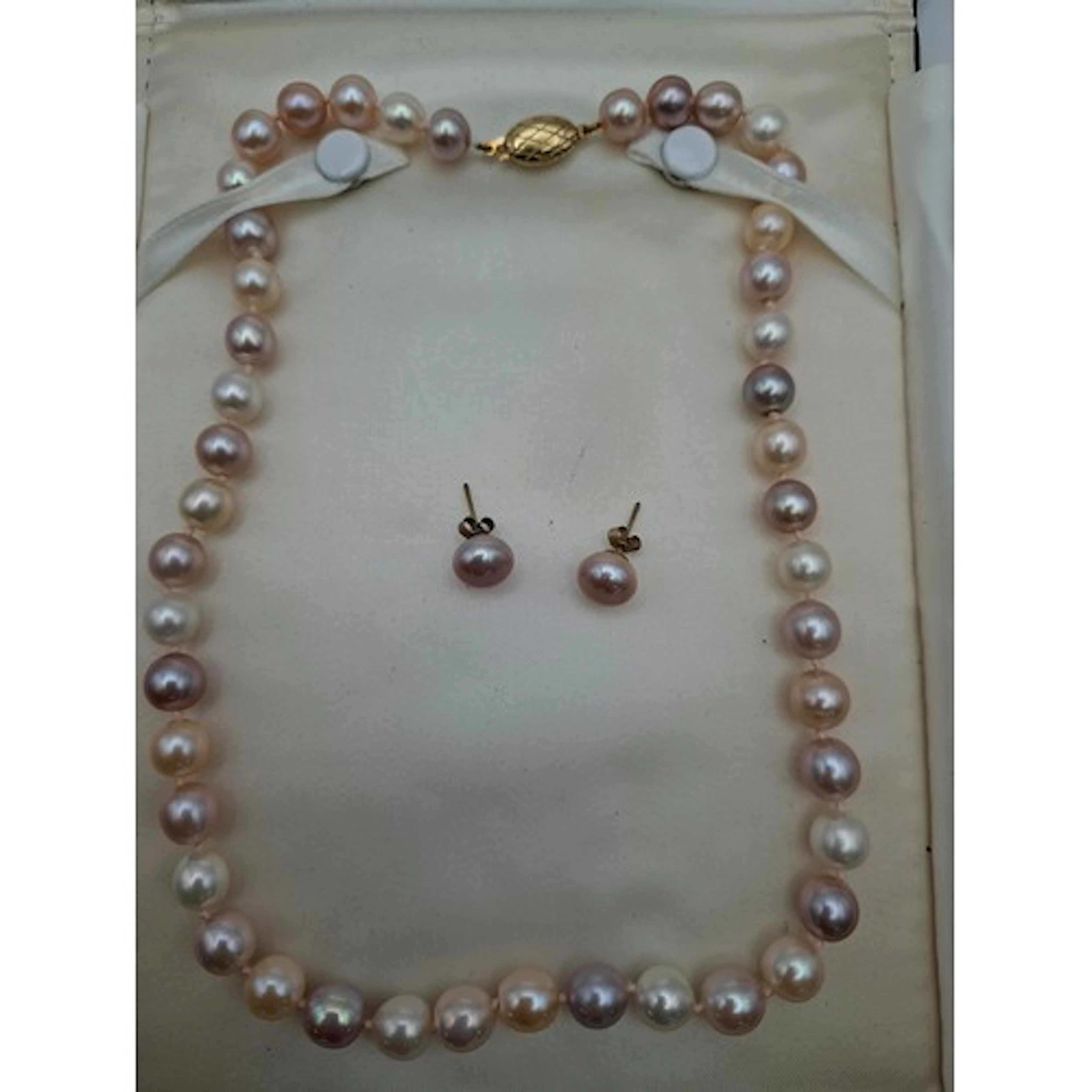 A string of freshwater coloured pearls on a silver gilt clas...