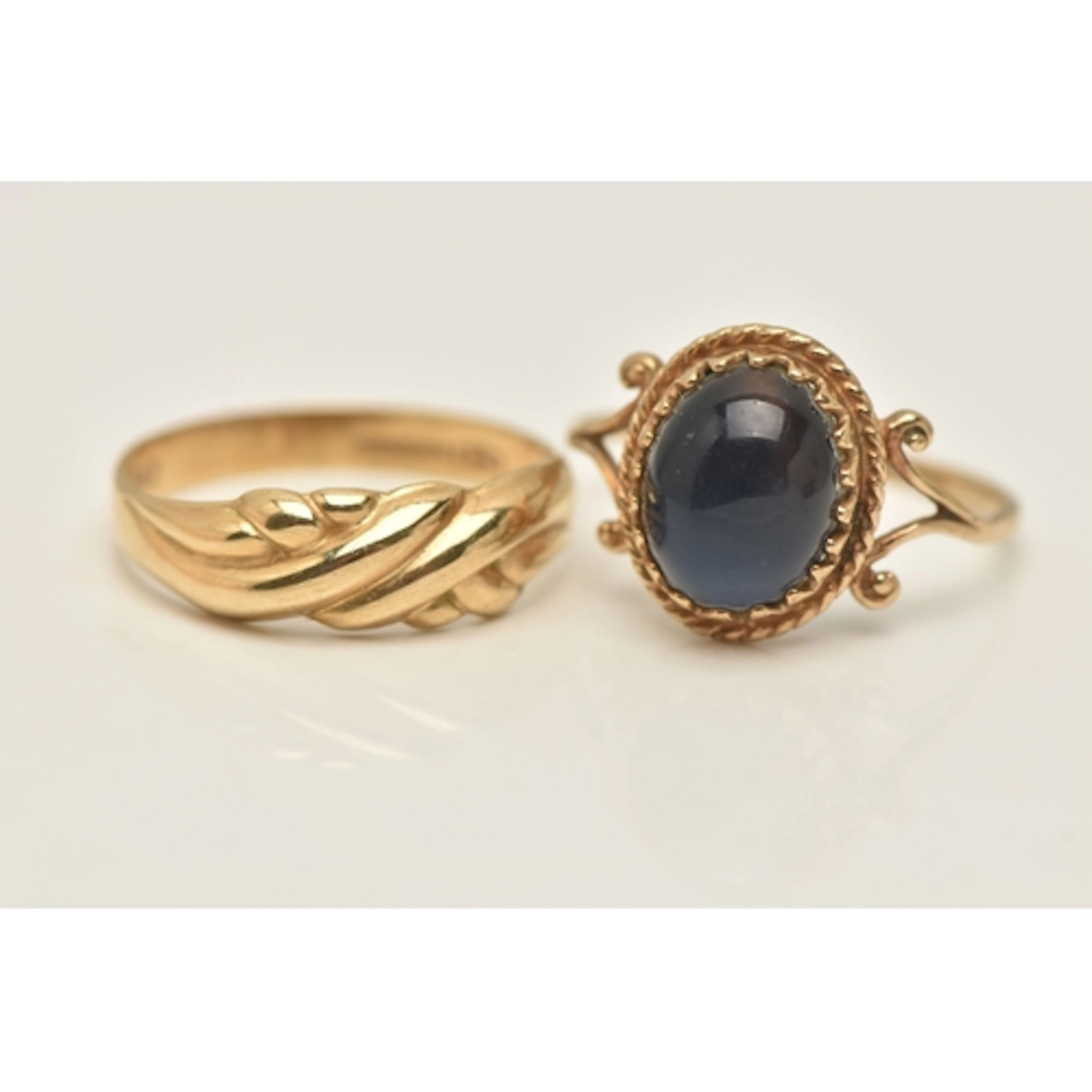TWO 9CT GOLD RINGS, the first of a cross over design, hallma...