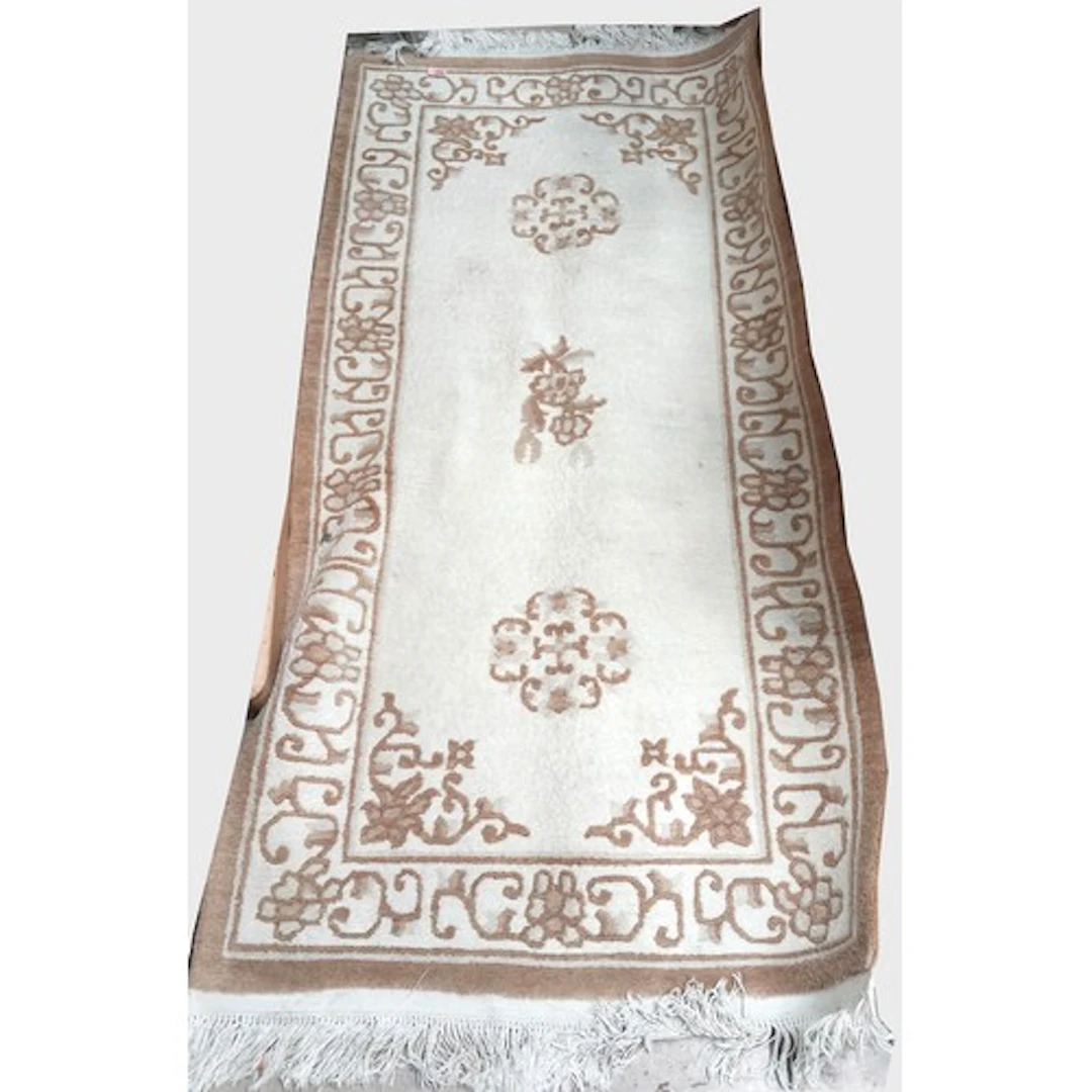 A fawn and cream patterned Chinese rug, 180cm length x 92cm ...