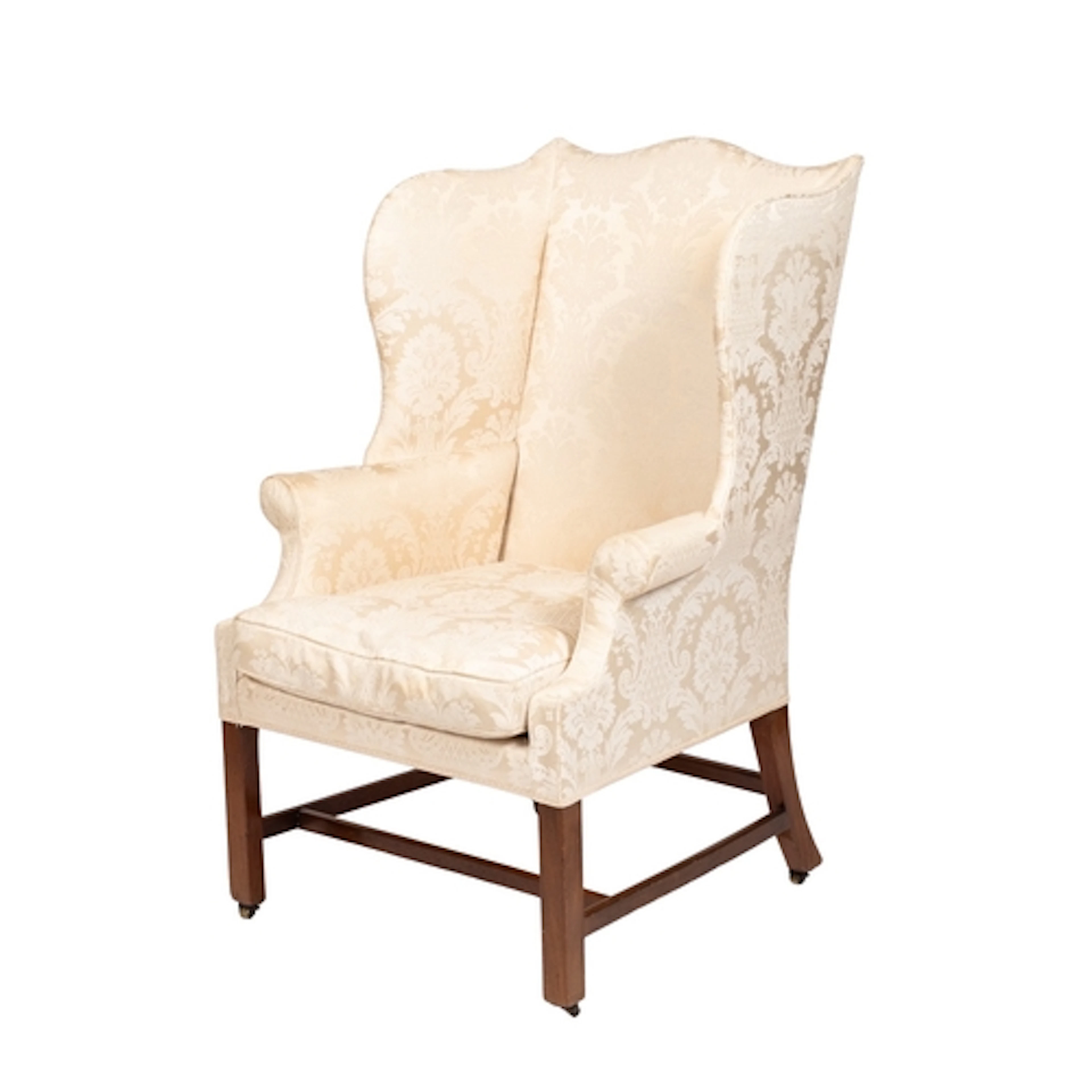 An upholstered wing armchair in George III style, early 20th...