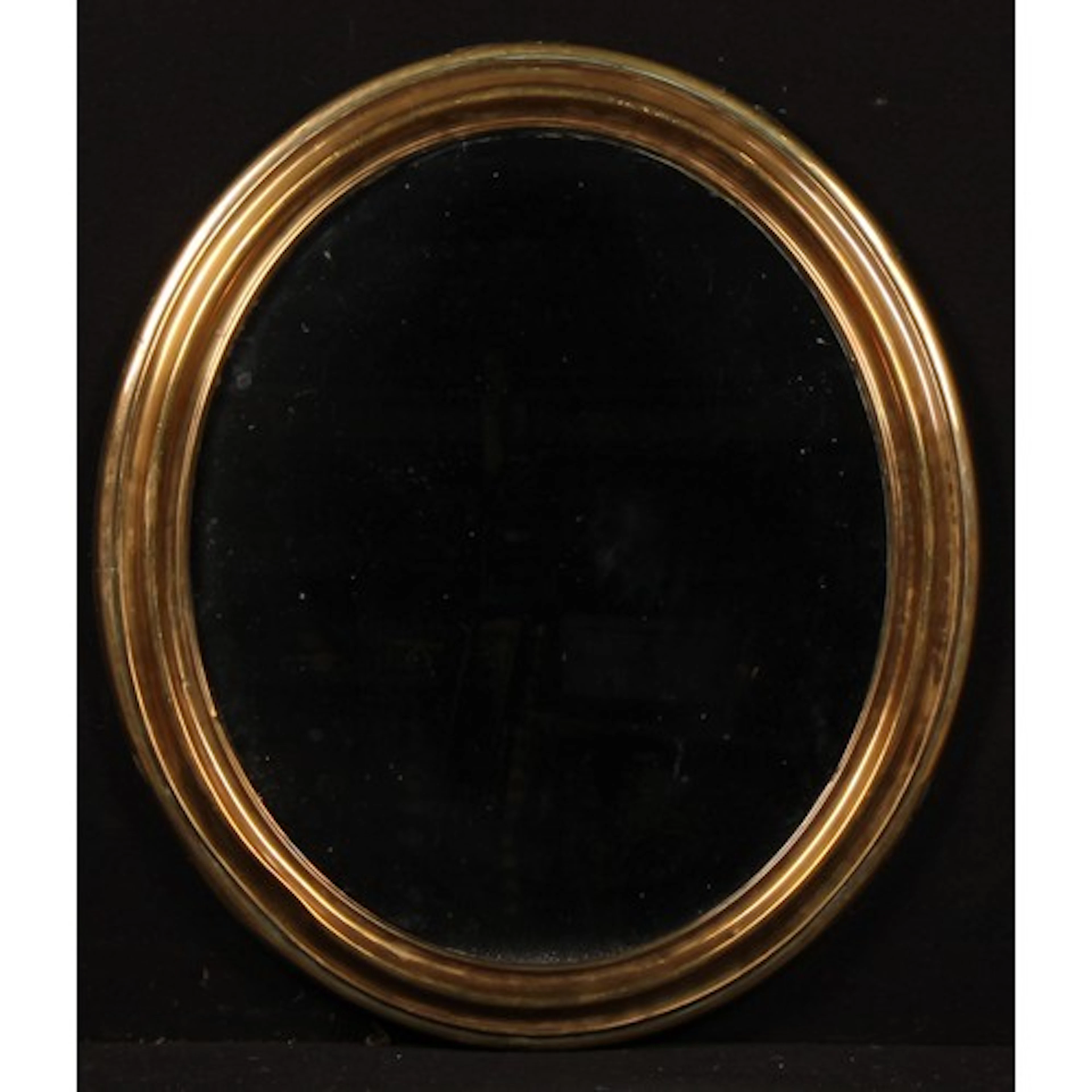 An early 20th century brass looking glass, oval mirror plate...