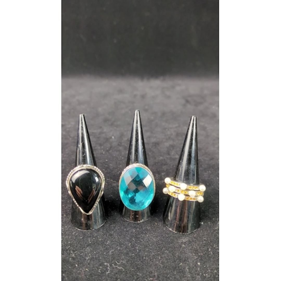 Three silver dress rings: a pear-shaped black cabochon in a ...