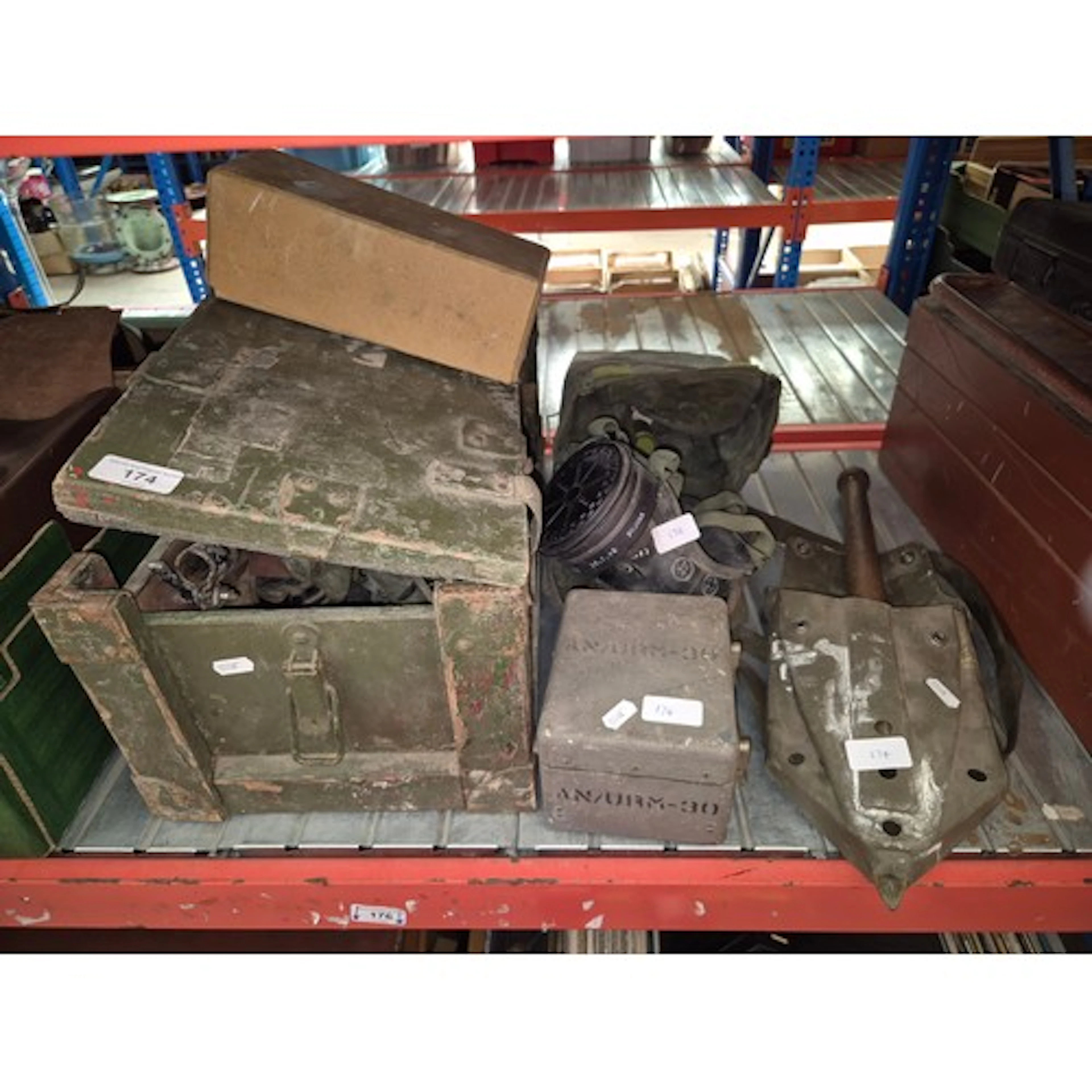 A wooden box containing a vintage mine detector, spade, mors...
