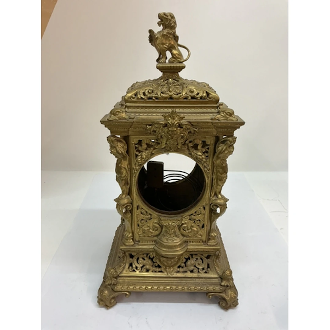 A brass mantle clock case, profusely decorated with scrollwo...