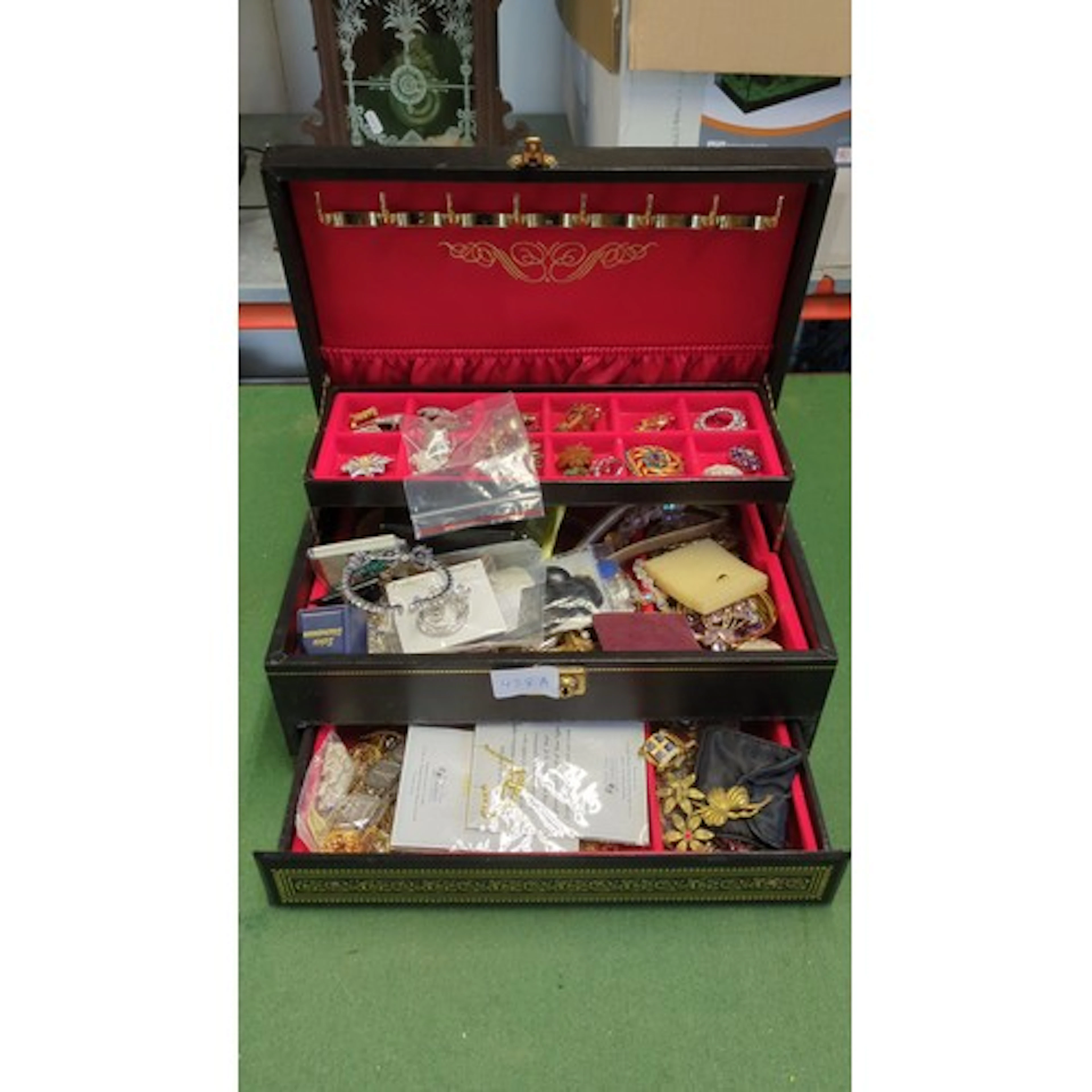 A black leatherette jewellery casket with hinged lid and fit...