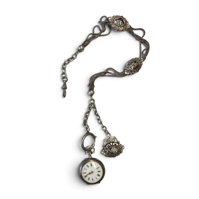 A Silver pocket watch with a silver chain, featuring silver ...