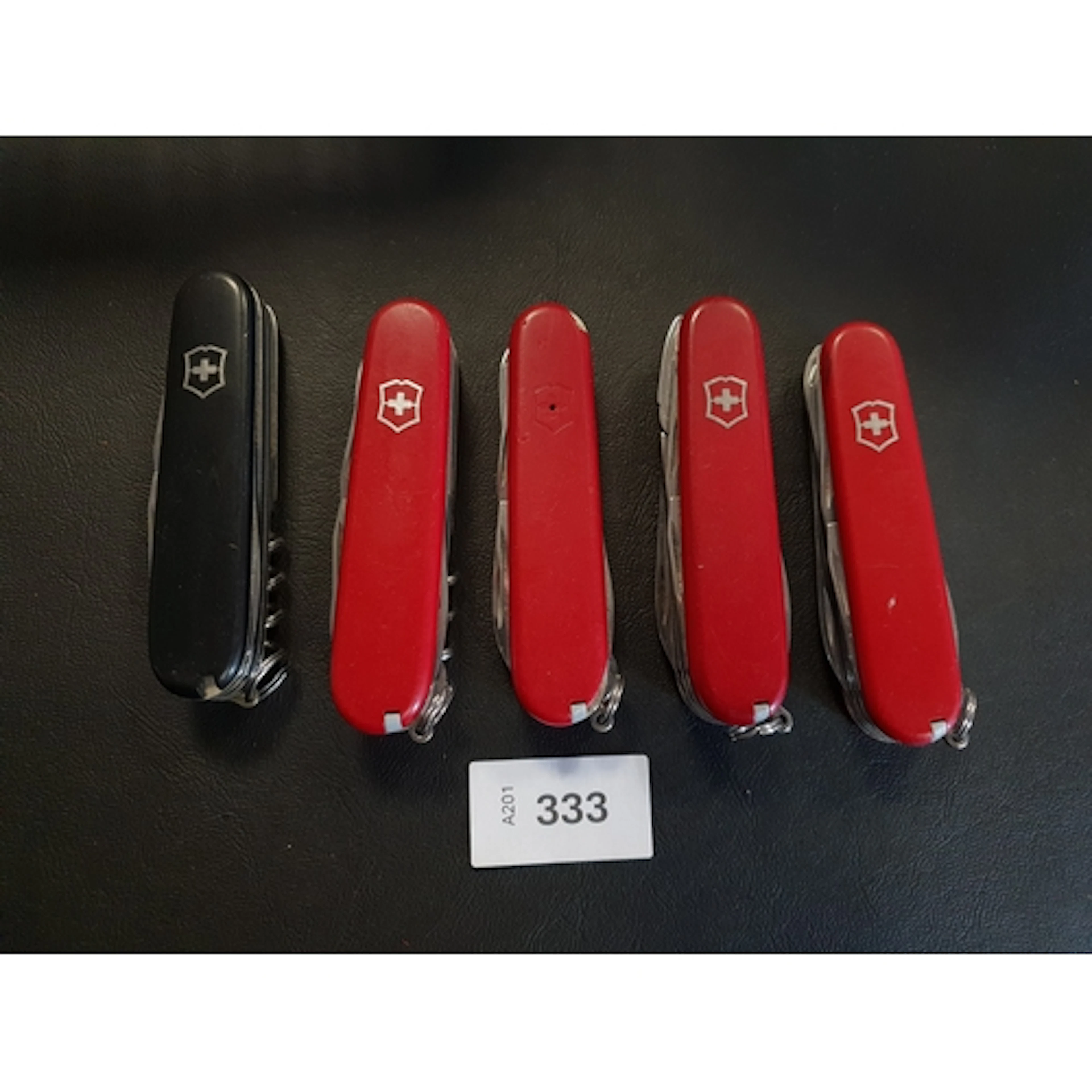 FIVE VICTORINOX SWISS ARMY KNIVES of various sizes and desig...