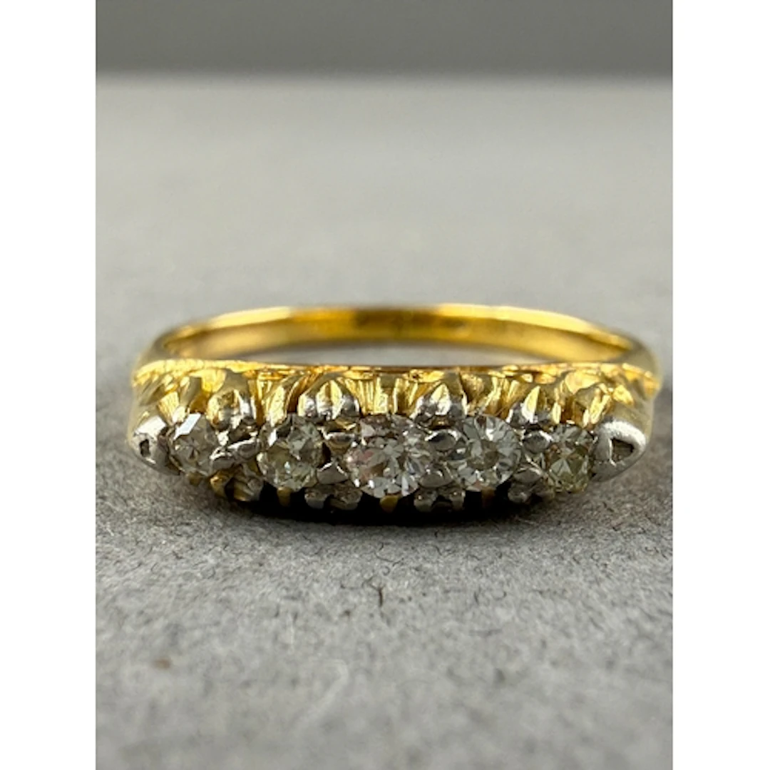 Jewellery: Yellow metal half hoop ring set with five graduat...
