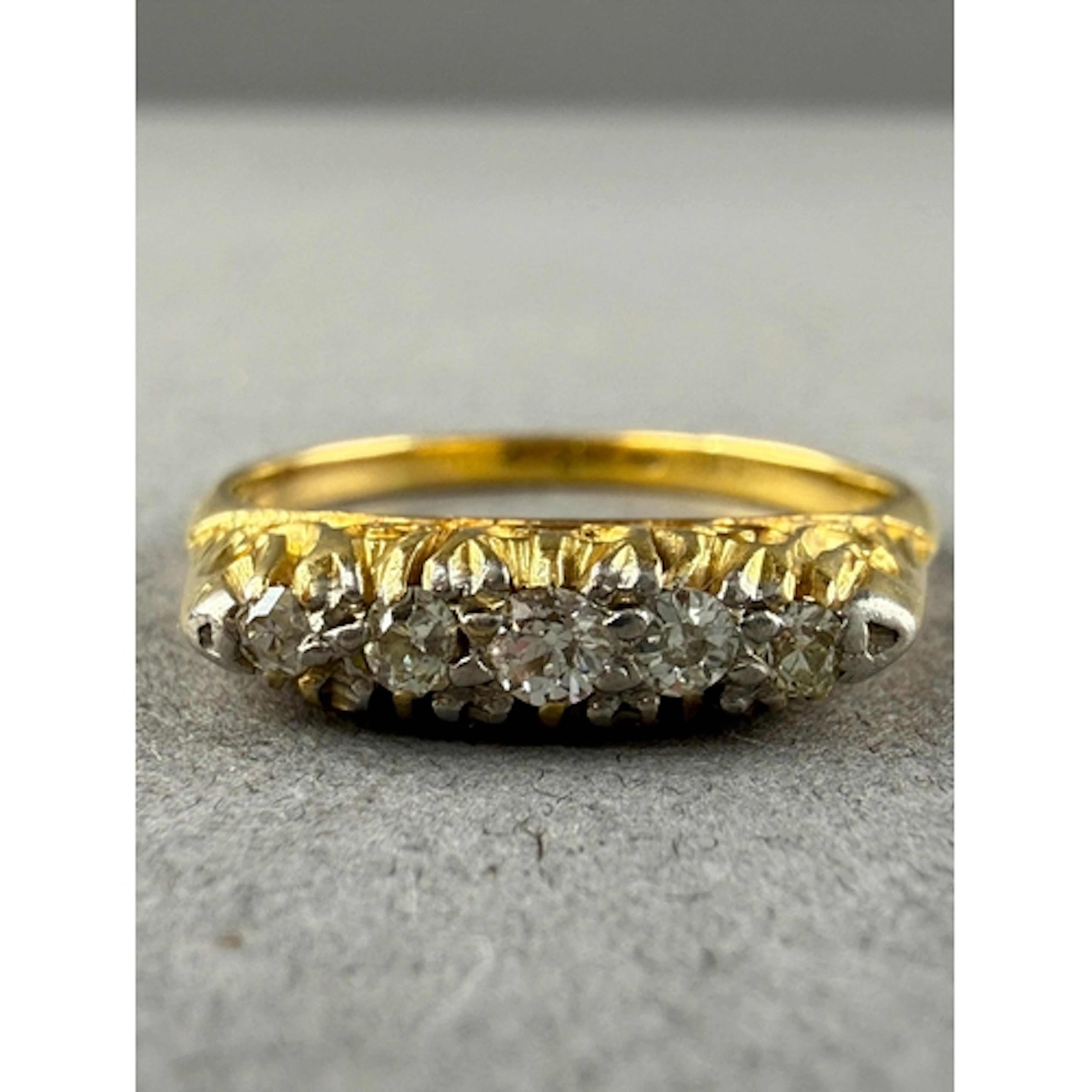 Jewellery: Yellow metal half hoop ring set with five graduat...