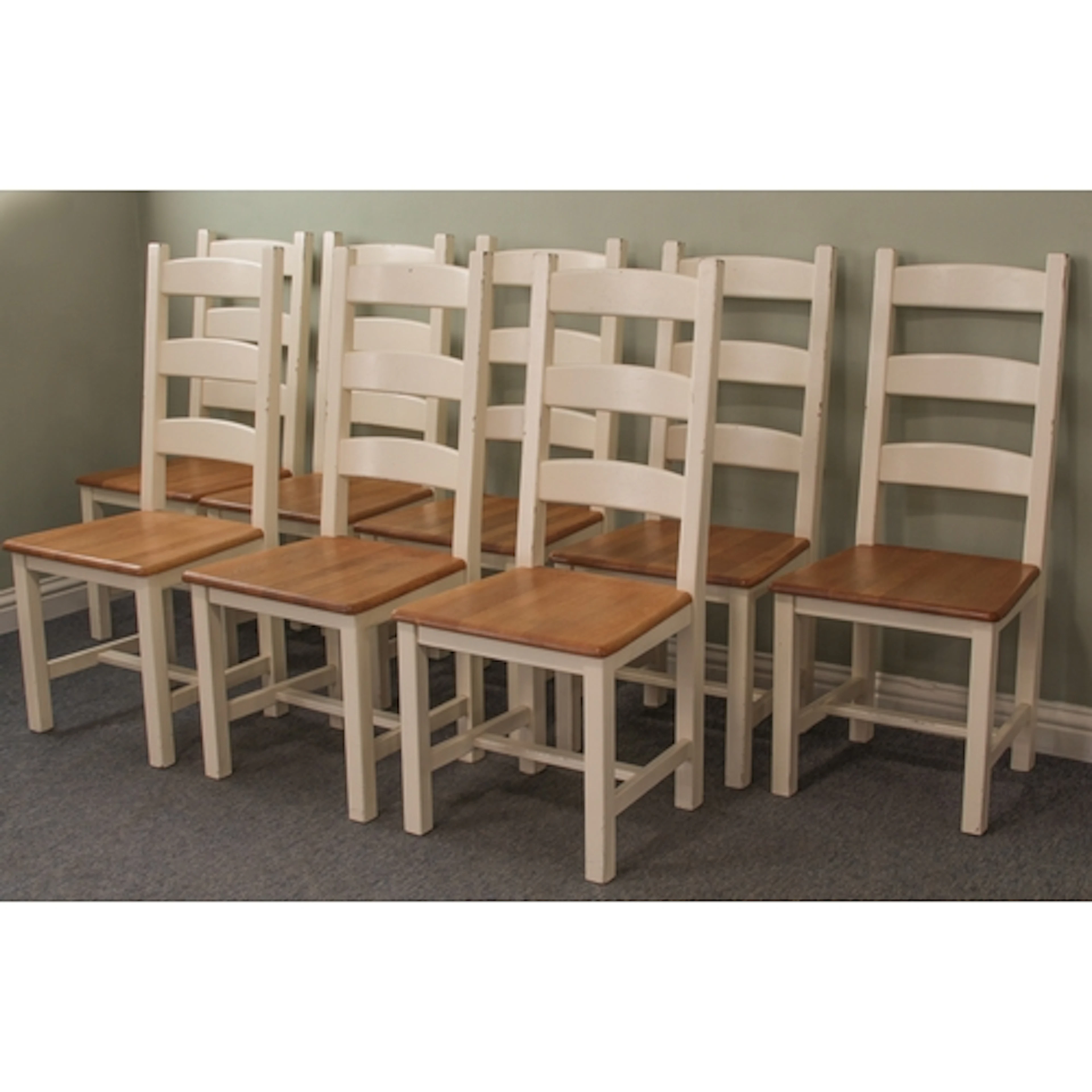 A set of eight white painted and light oak ladderback dining...