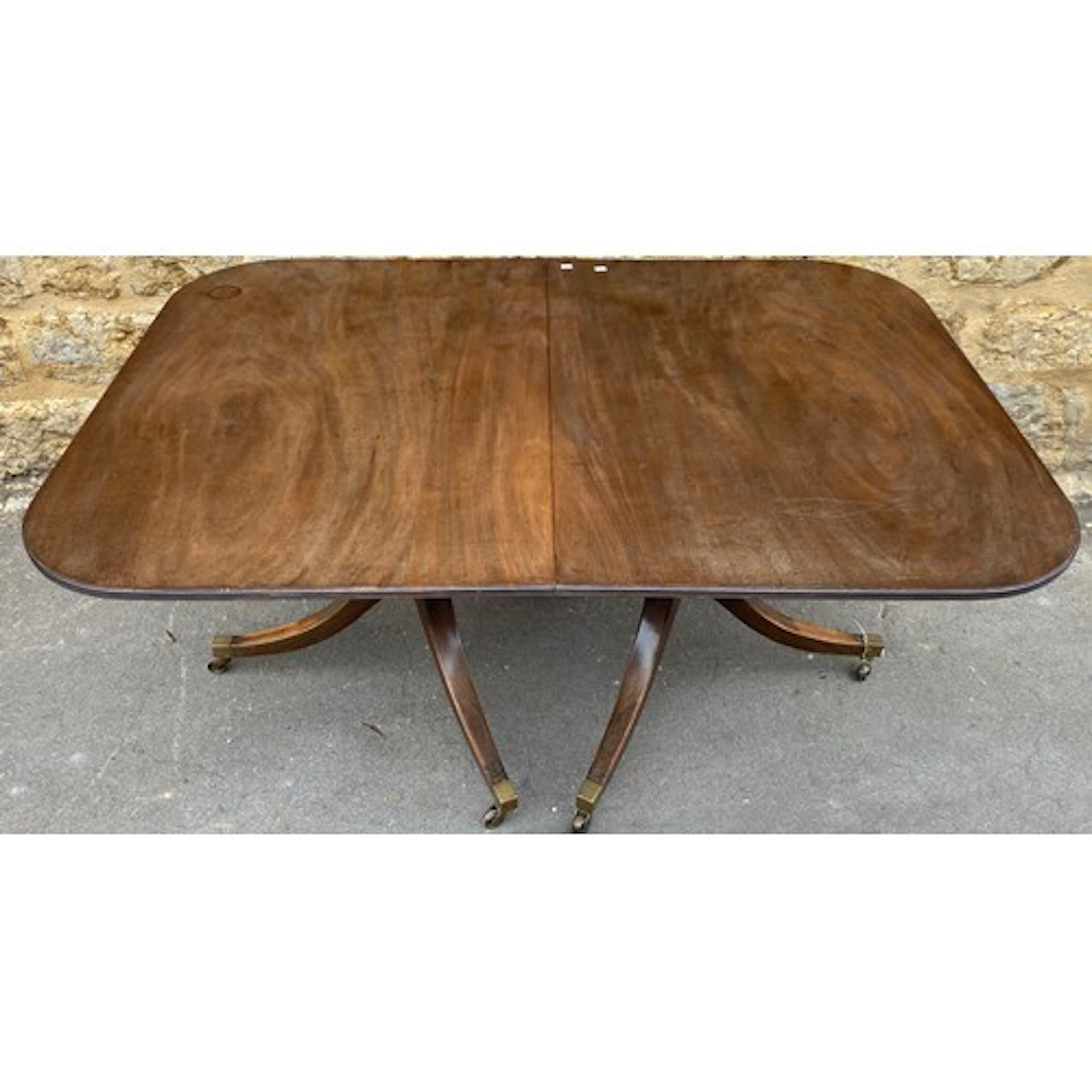 A mahogany pedestal dining table in Regency style with two s...