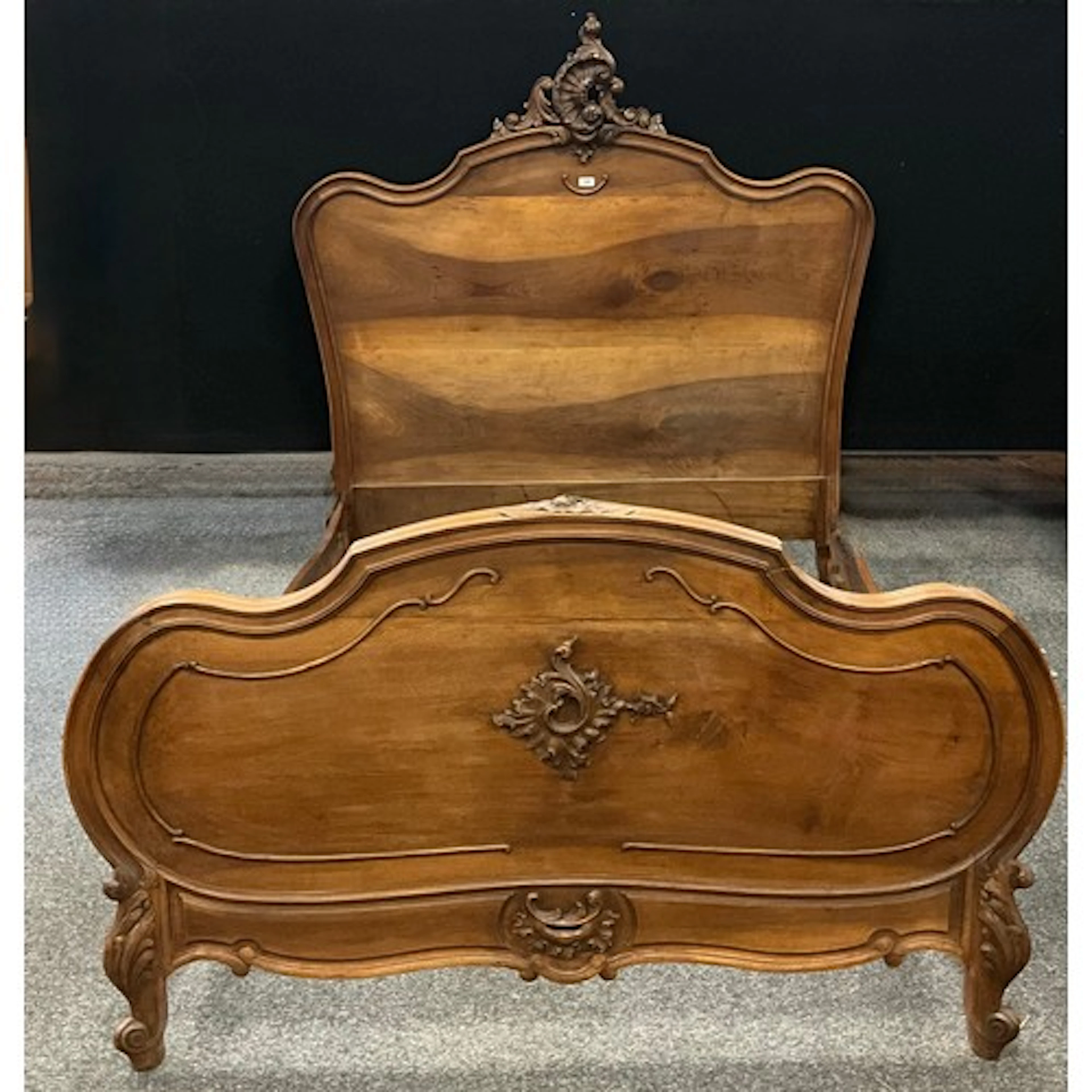 A Baroque style walnut queen sized bed frame, with central r...