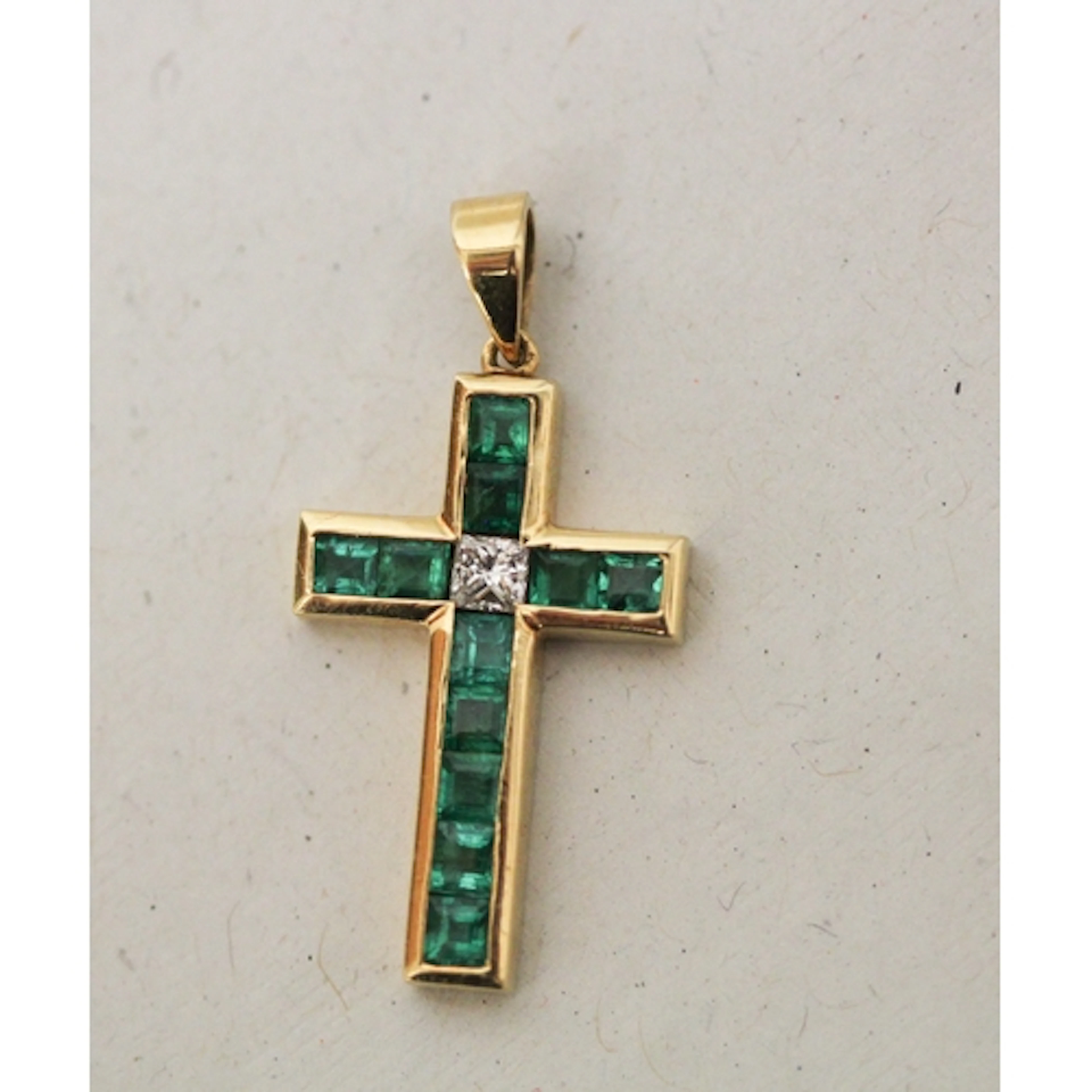 An 18ct yellow gold emerald and diamond cross pendant, with ...
