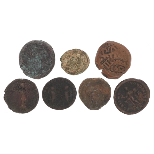 Seven bronze Roman coins depicting various emperors, the lar...