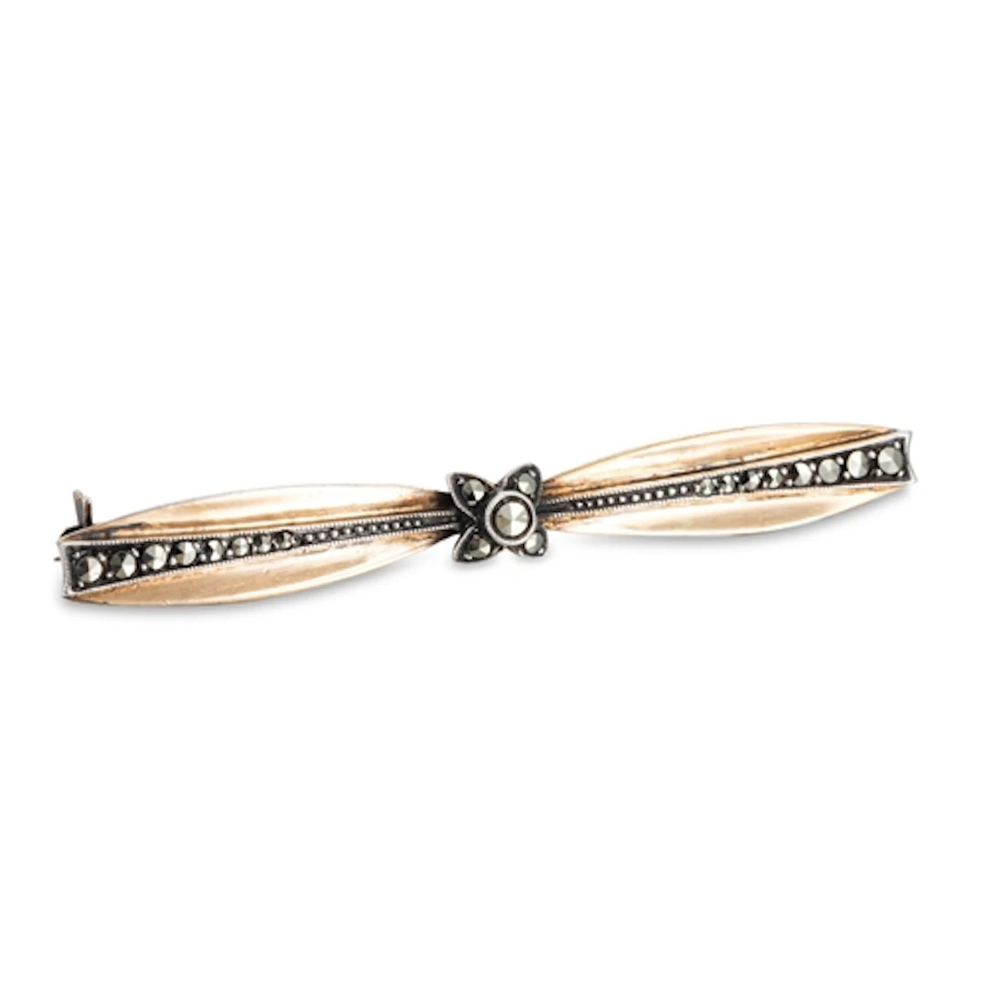 AN ART DECO STYLISED BOW BROOCH, c. 1935, set with marcasite...