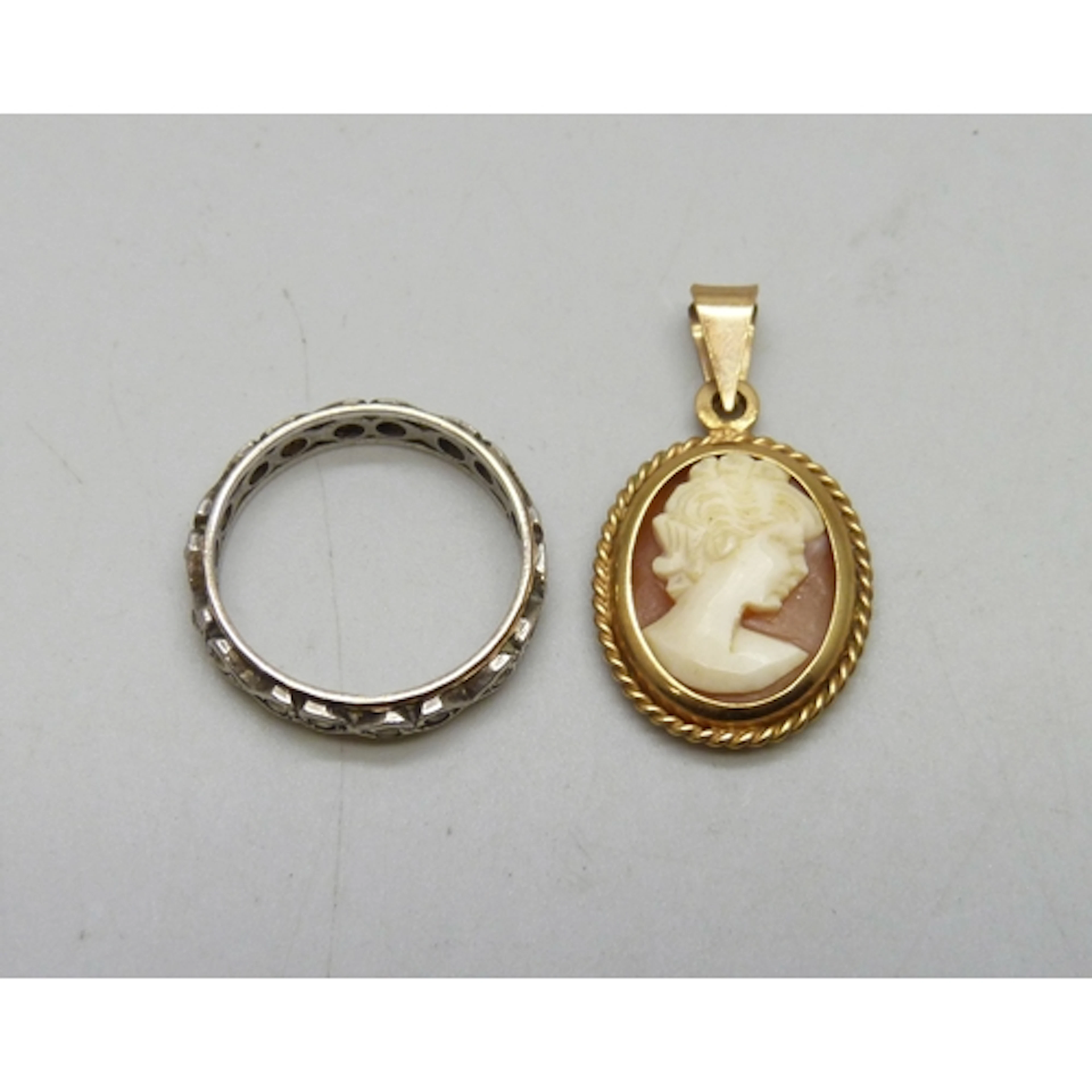 A 9ct gold cameo pendant, 1.5g, and a 9ct gold and silver ri...