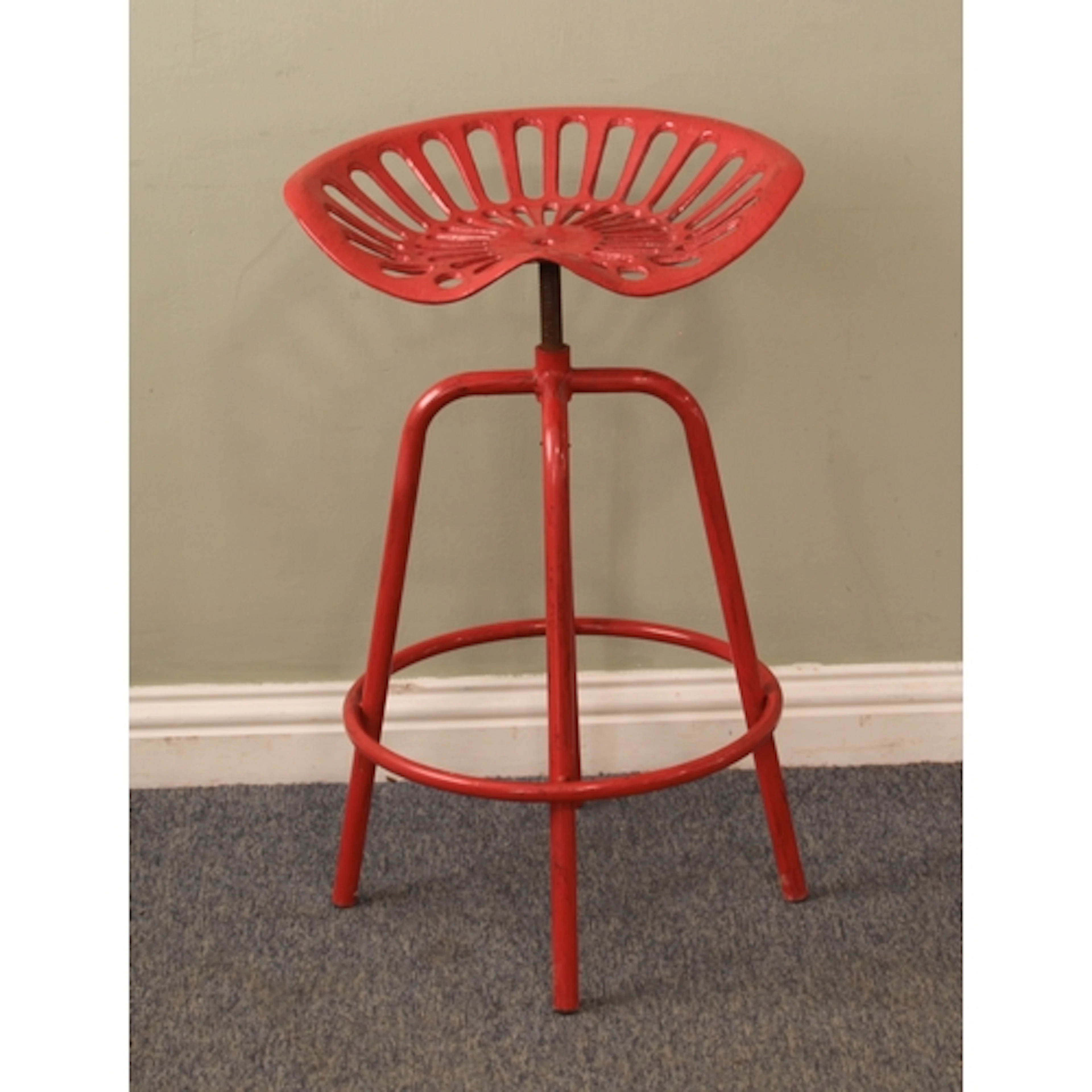 A vintage tractor-seat bar stool - the red-painted cast-iron...