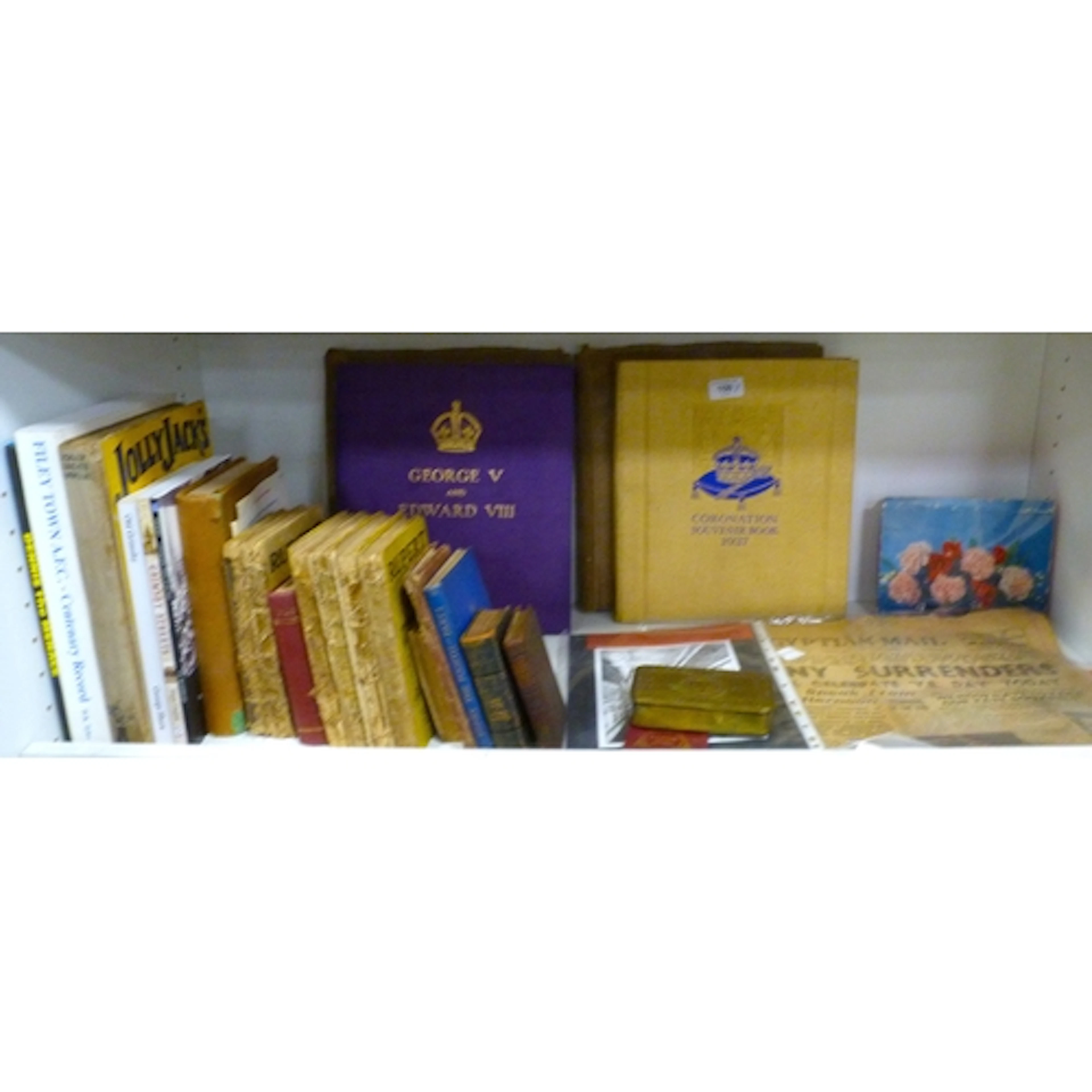 Shelf of ephemera and books to include Coronation 1937 souve...