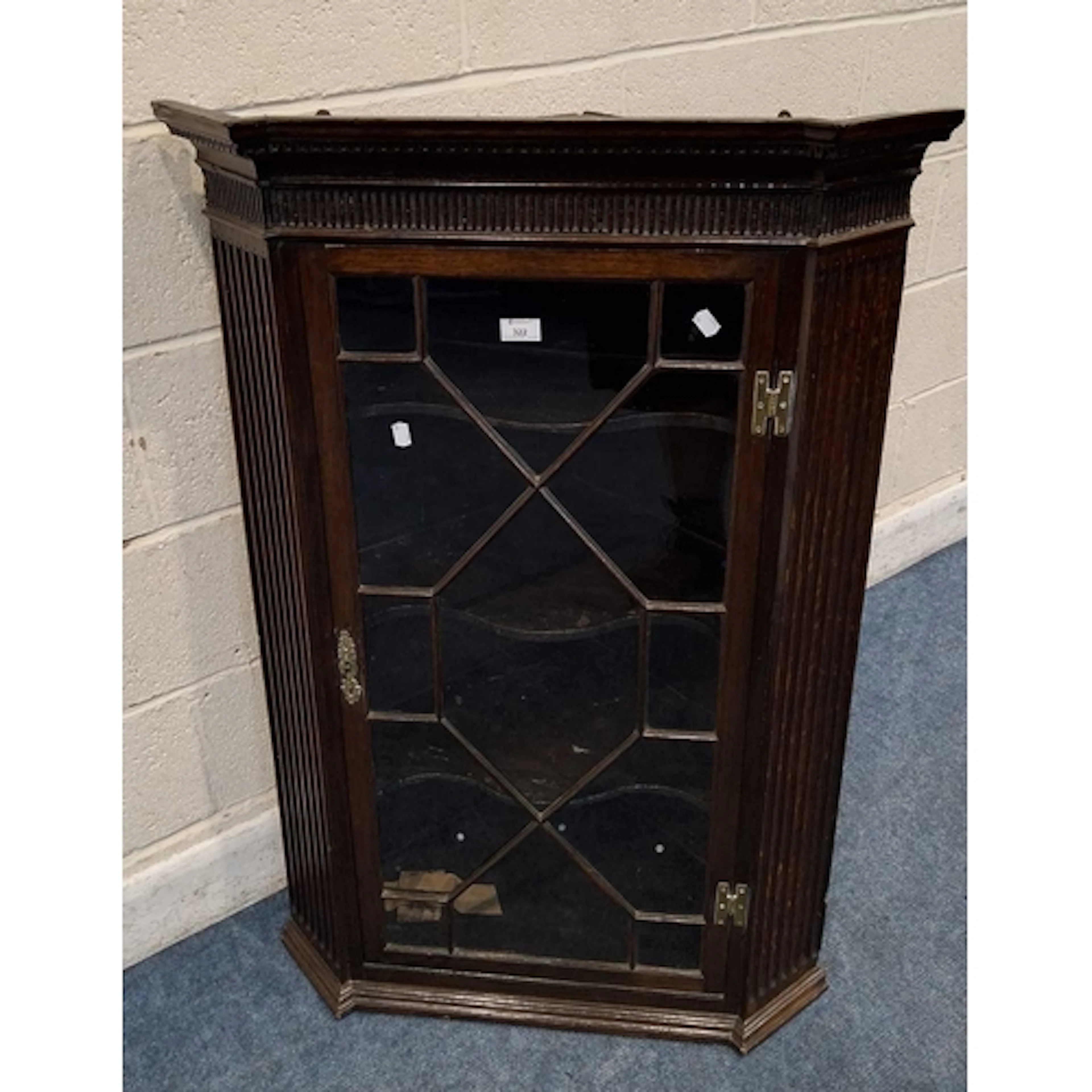 A GEORGIAN OAK WALL HANGING CORNER CUPBOARD, fitted with a s...
