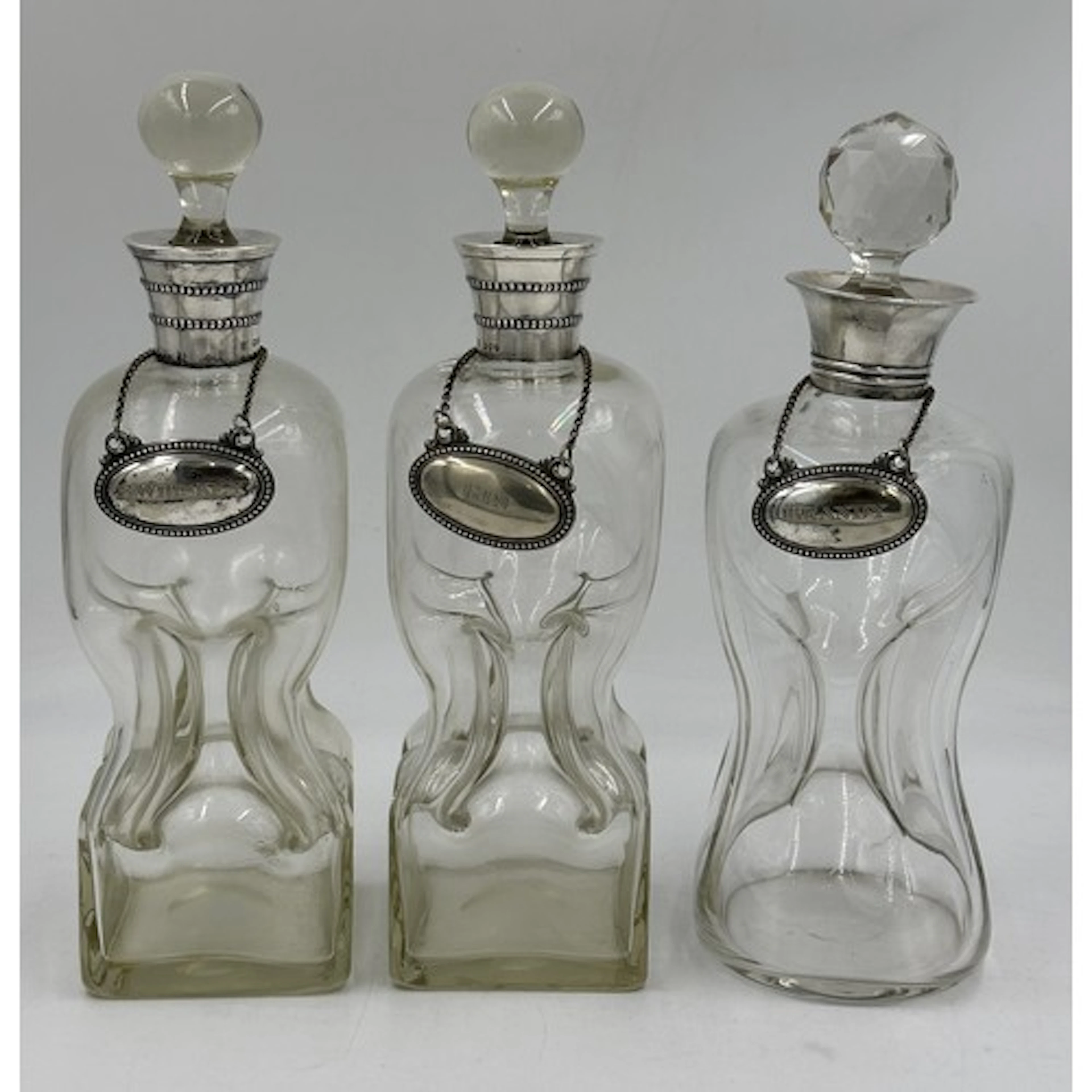 Three Victorian silver mounted glass glug glug decanters to ...