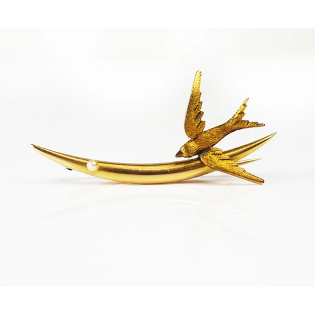 An Edwardian 15ct gold crescent and swallow brooch set with ...