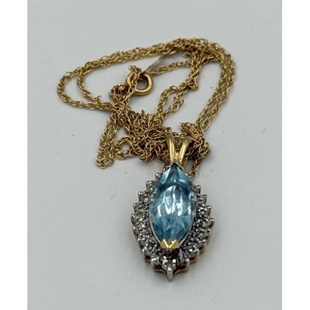 A marquise-cut aquamarine with a diamond surround on a fine ...