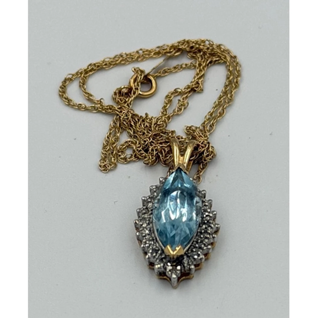 A marquise-cut aquamarine with a diamond surround on a fine ...