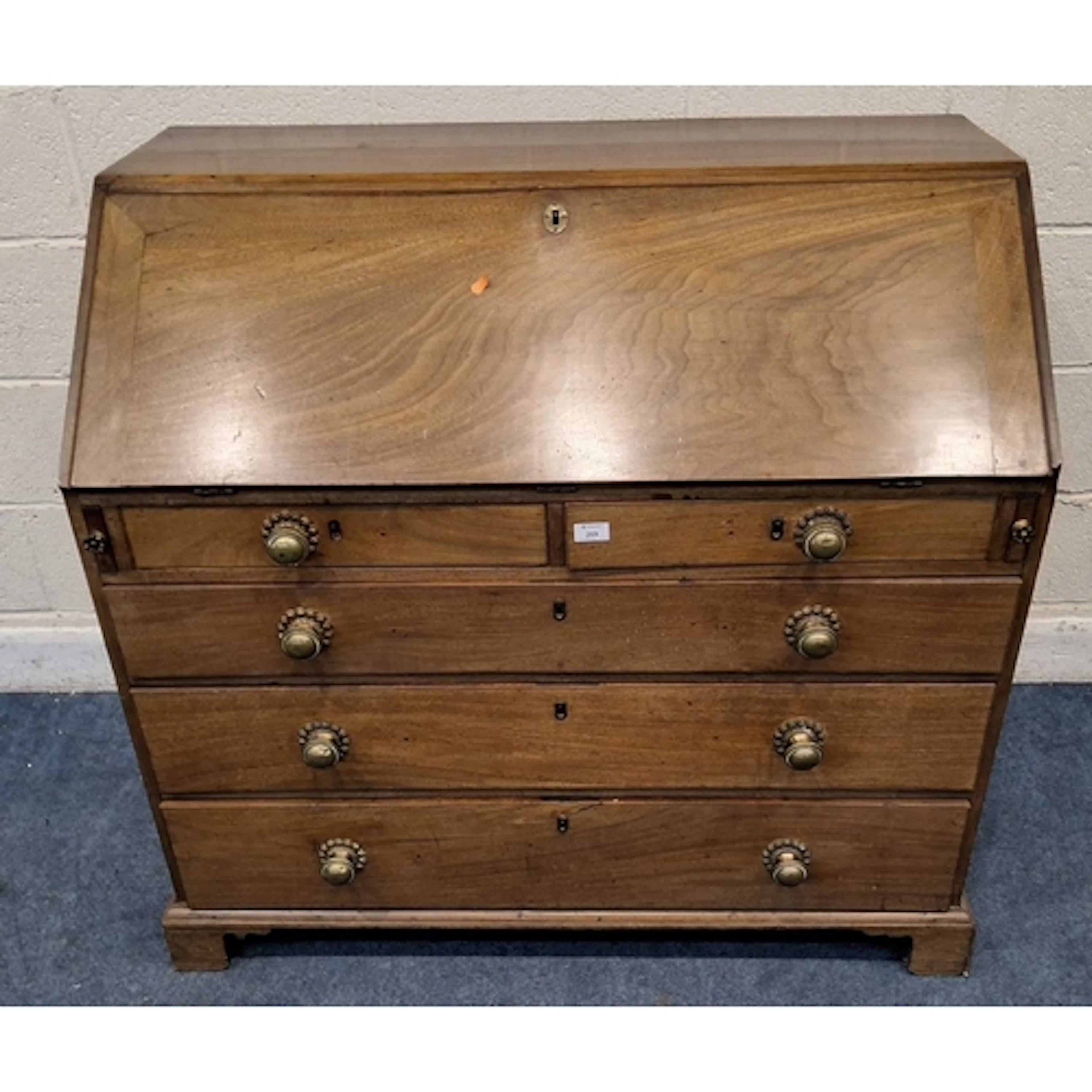 A GEORGIAN MAHOGANY BUREAU, the fall front door enclosing a ...
