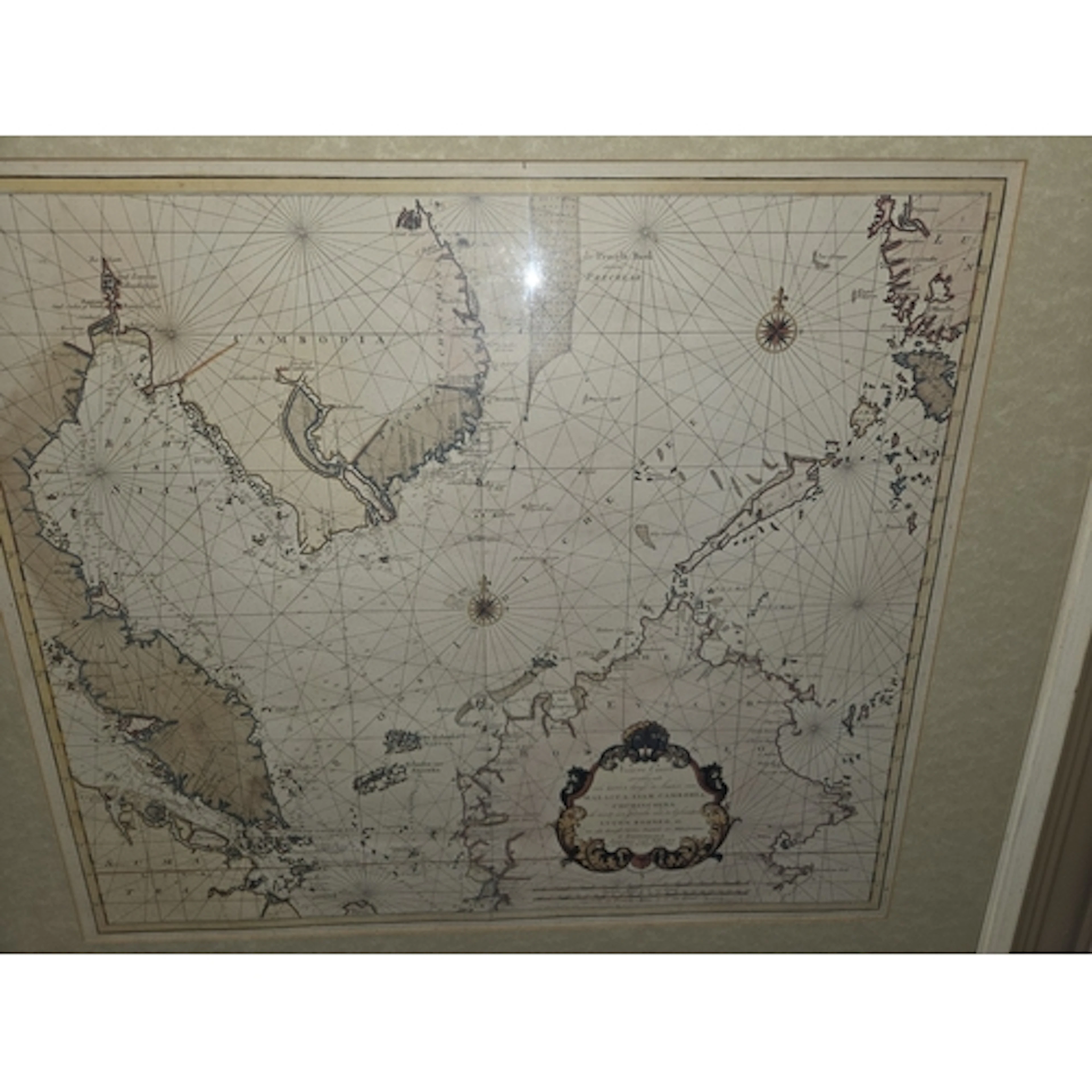 A large framed mirror with design and vintage map