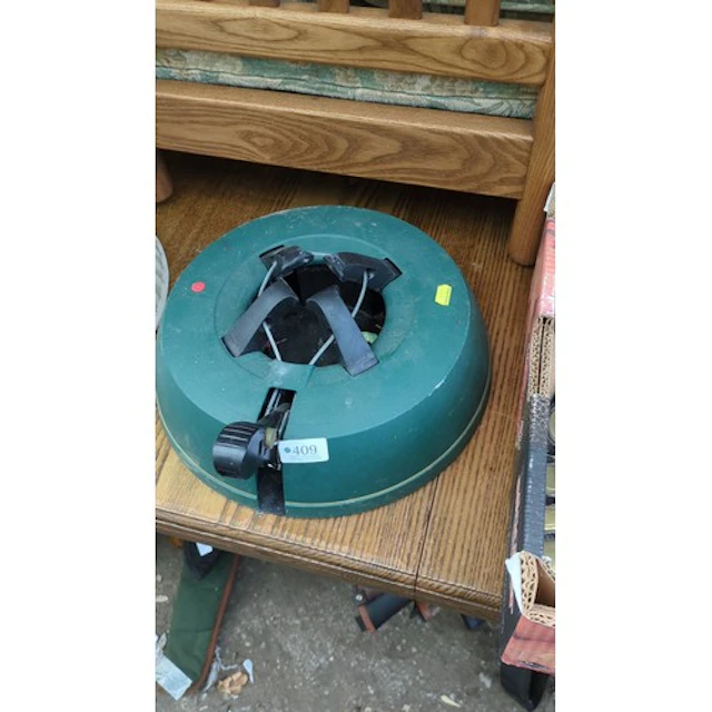 Christmas tree stand in green moulded plastic, with four cab...