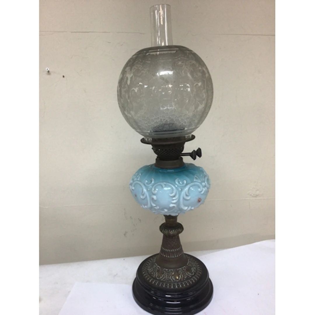 A Victorian oil lamp with a coloured glass reservoir acid et...