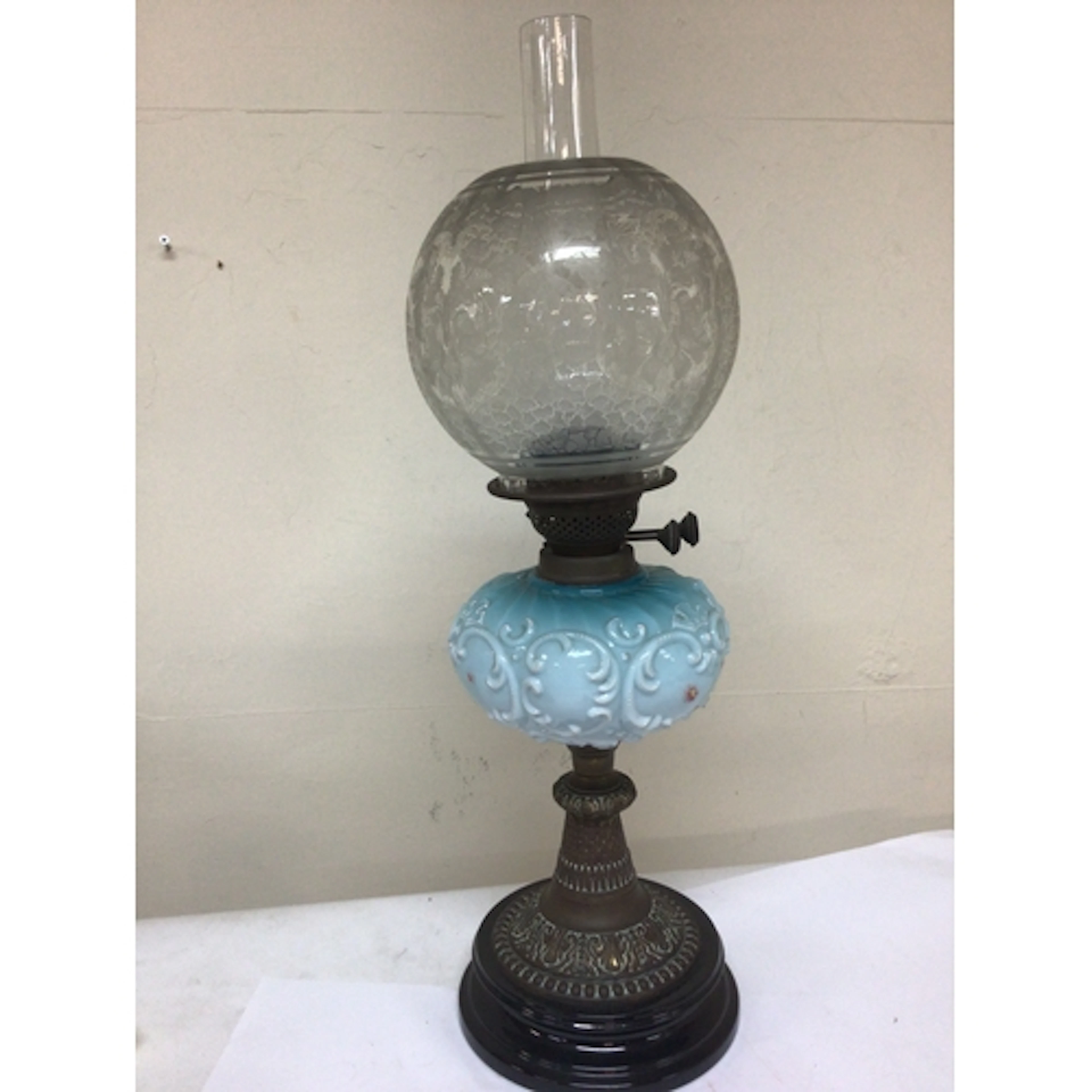 A Victorian oil lamp with a coloured glass reservoir acid et...