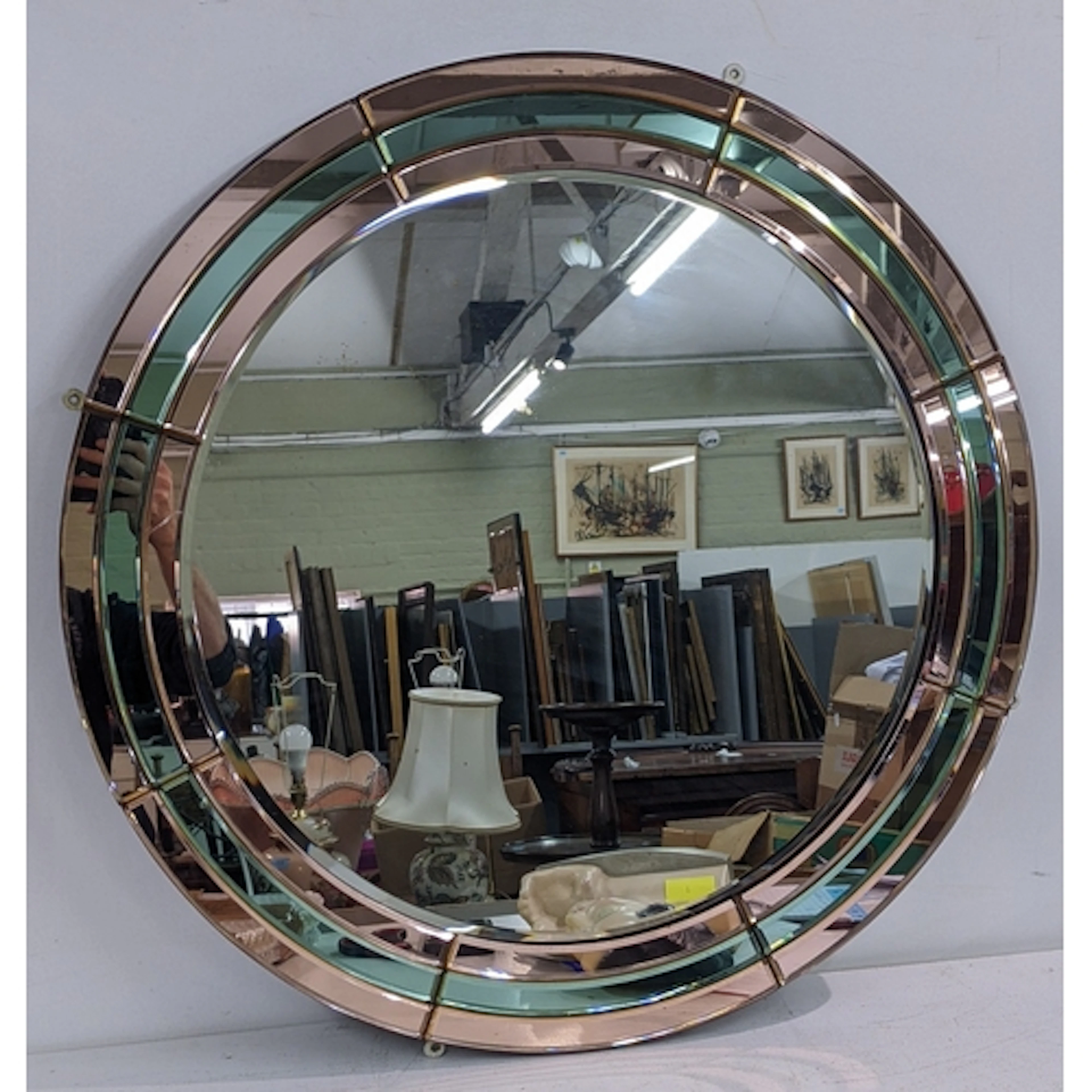 An Art Deco circular wall hanging mirror having a tinted gla...
