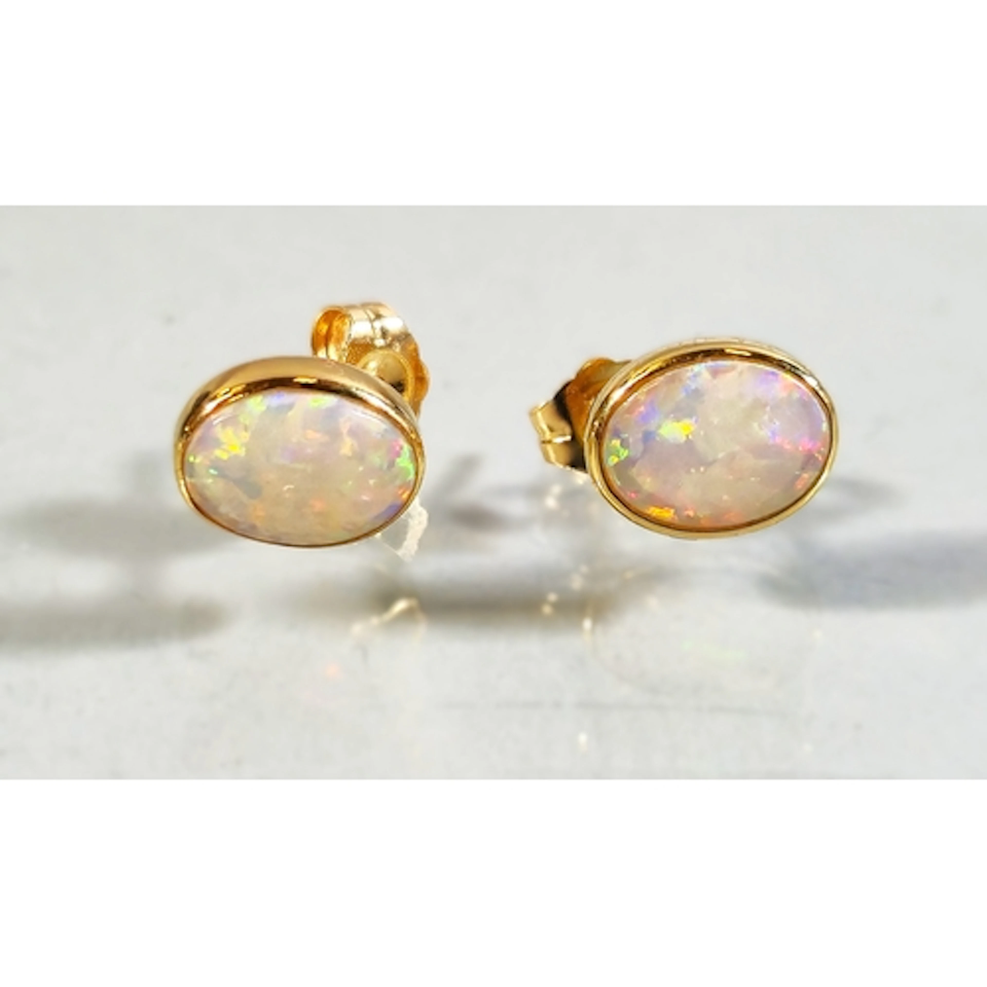Pair of 18ct gold opal earrings set with a vibrant oval opal...