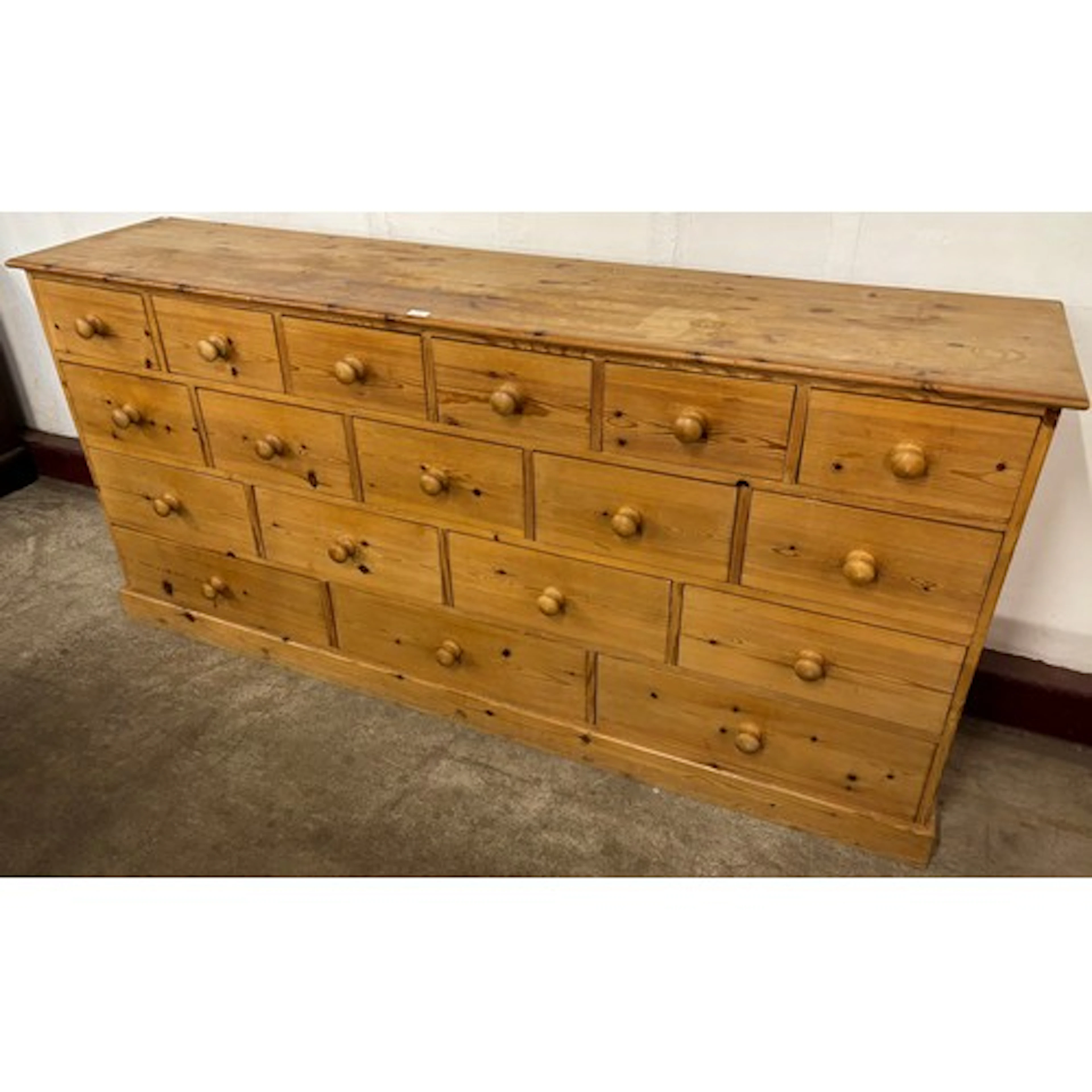 A Victorian style pine bank of eighteen drawers