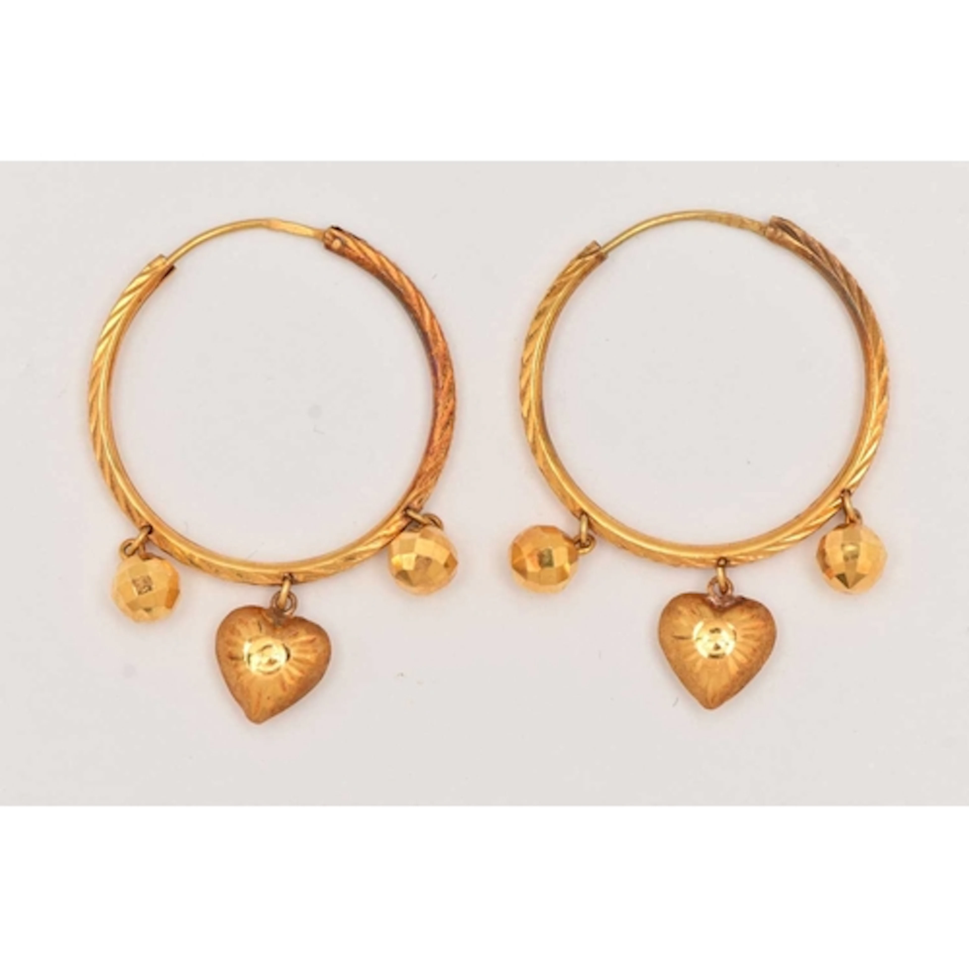 A PAIR OF YELLOW METAL HOOP EARRINGS, textured hoops attache...