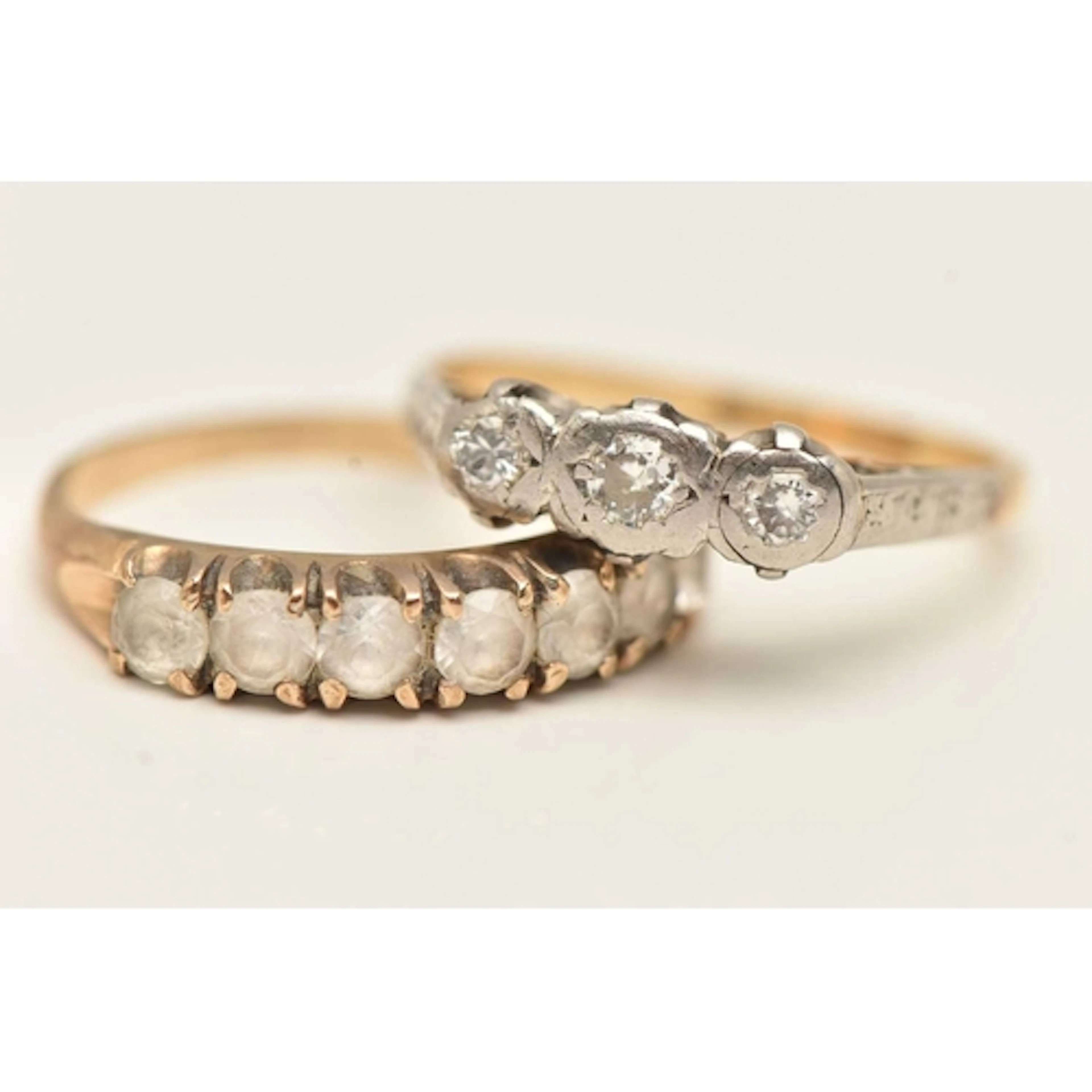 TWO GEM SET RINGS, the first a yellow metal three stone diam...