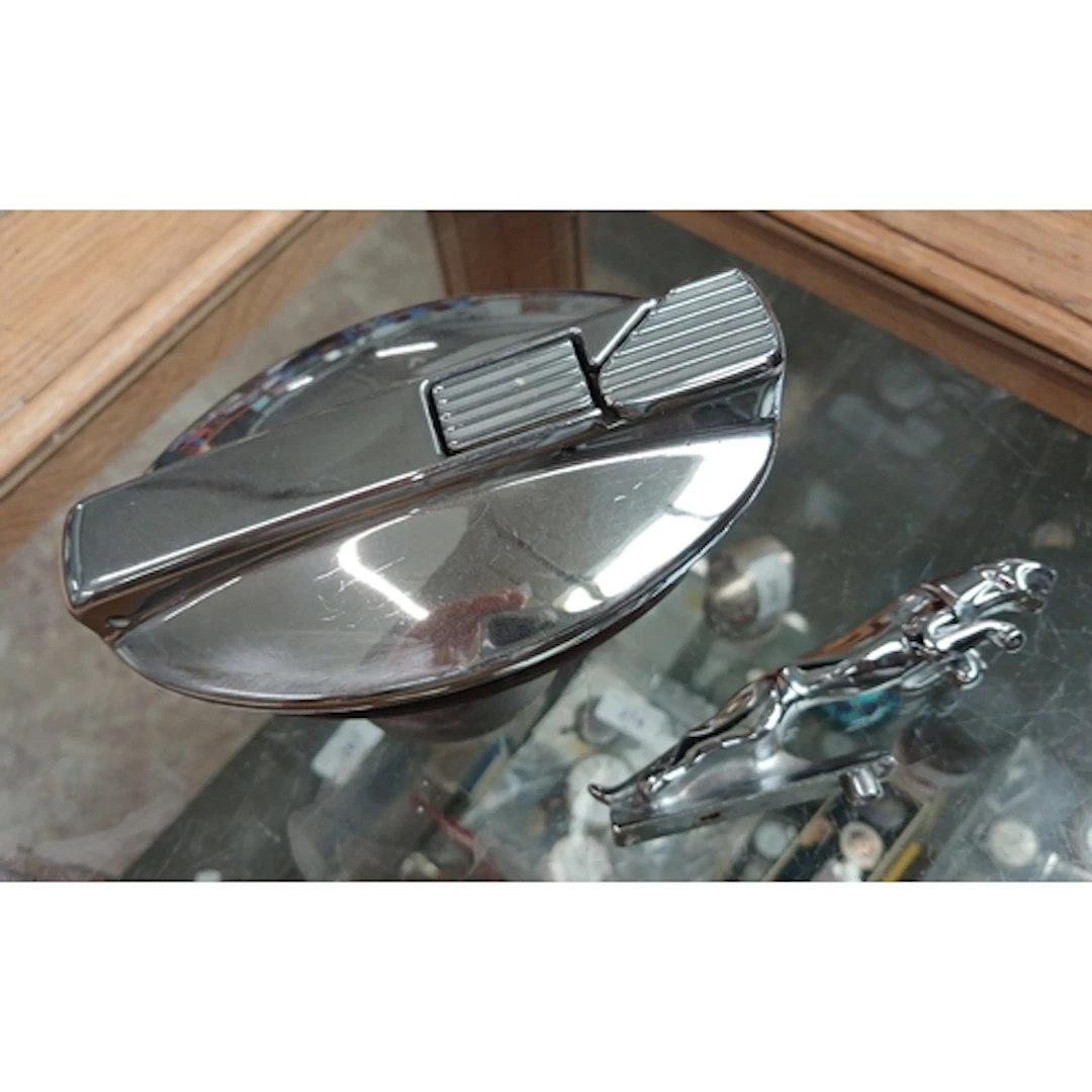 A Jaguar car mascot and a petrol cap.