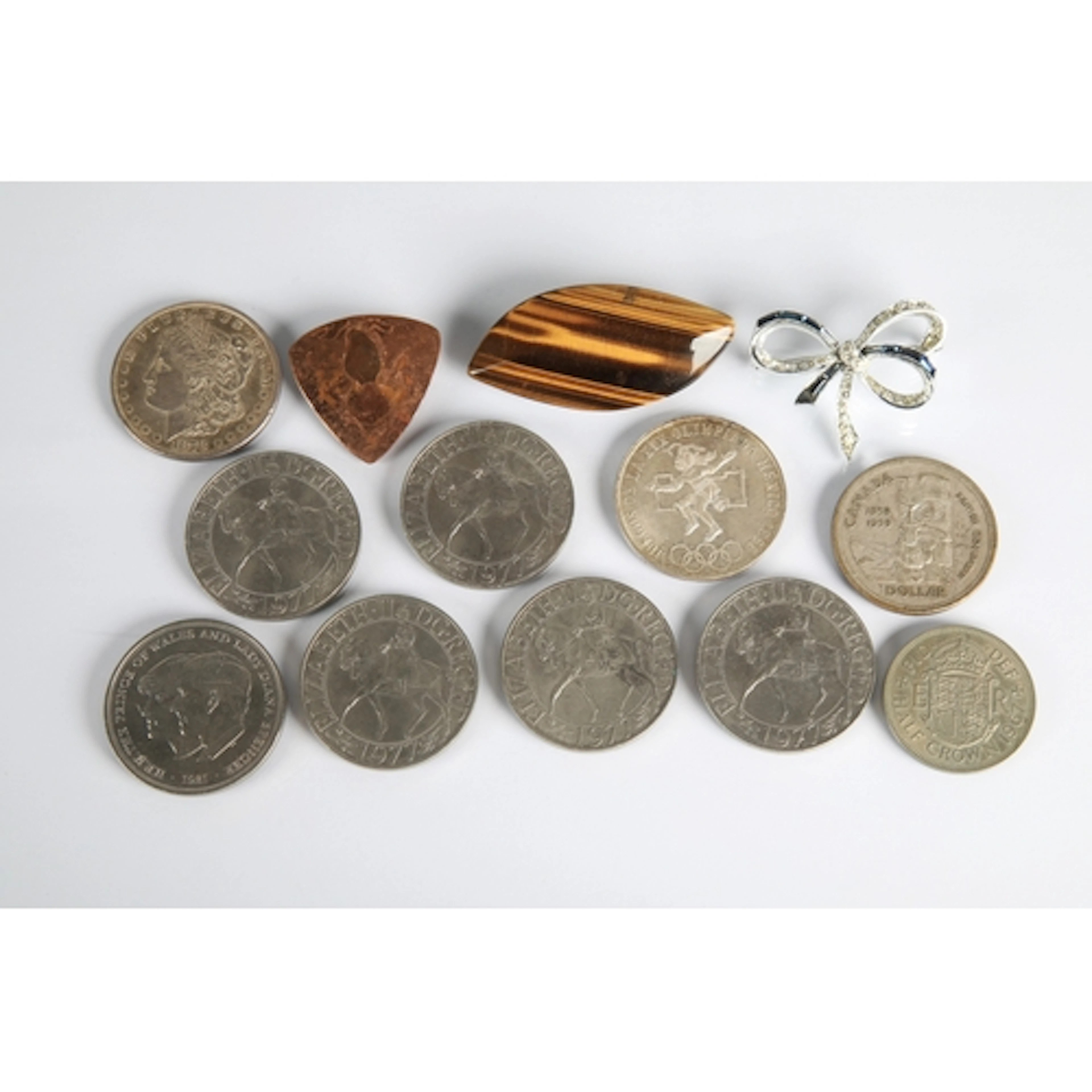 Box of assorted British crowns, US dollar, Tigers eye brooch...