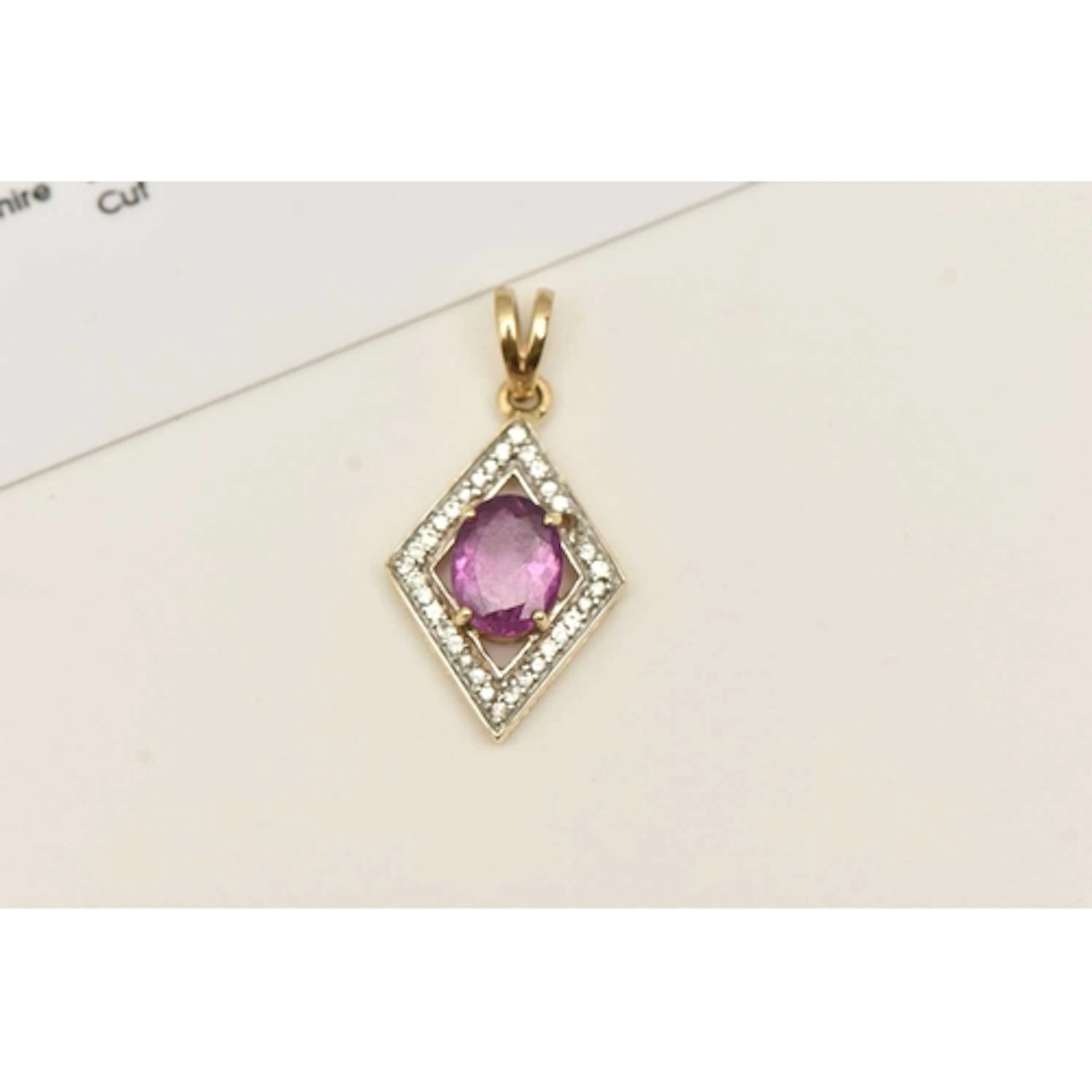 A 9CT YELLOW GOLD GEM SET PENDANT, an oval cut pink purple t...