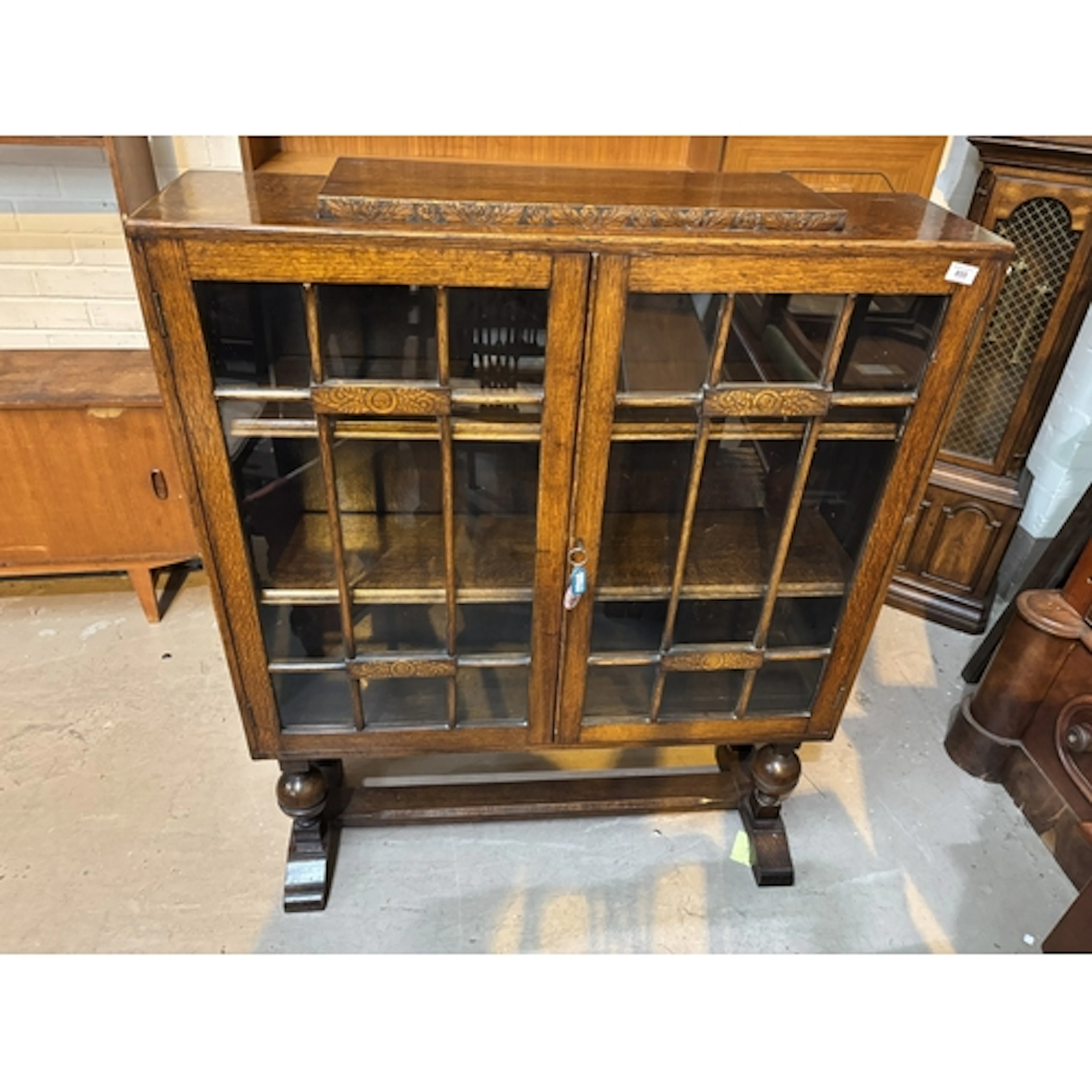 An early 20th century oak display cabinet with exposed dovet...